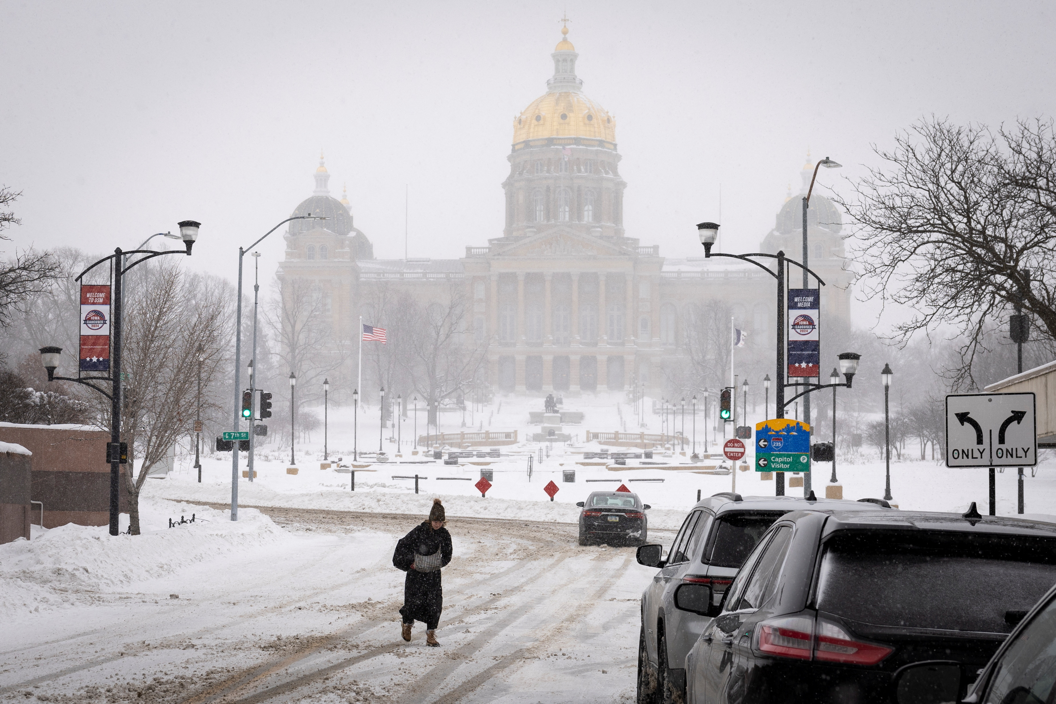 A woman walks in the street in front of Iowa state capitol after a blizzard left several inches of snow, in downtown Des Moines, Iowa, U.S., January 13, 2024. 