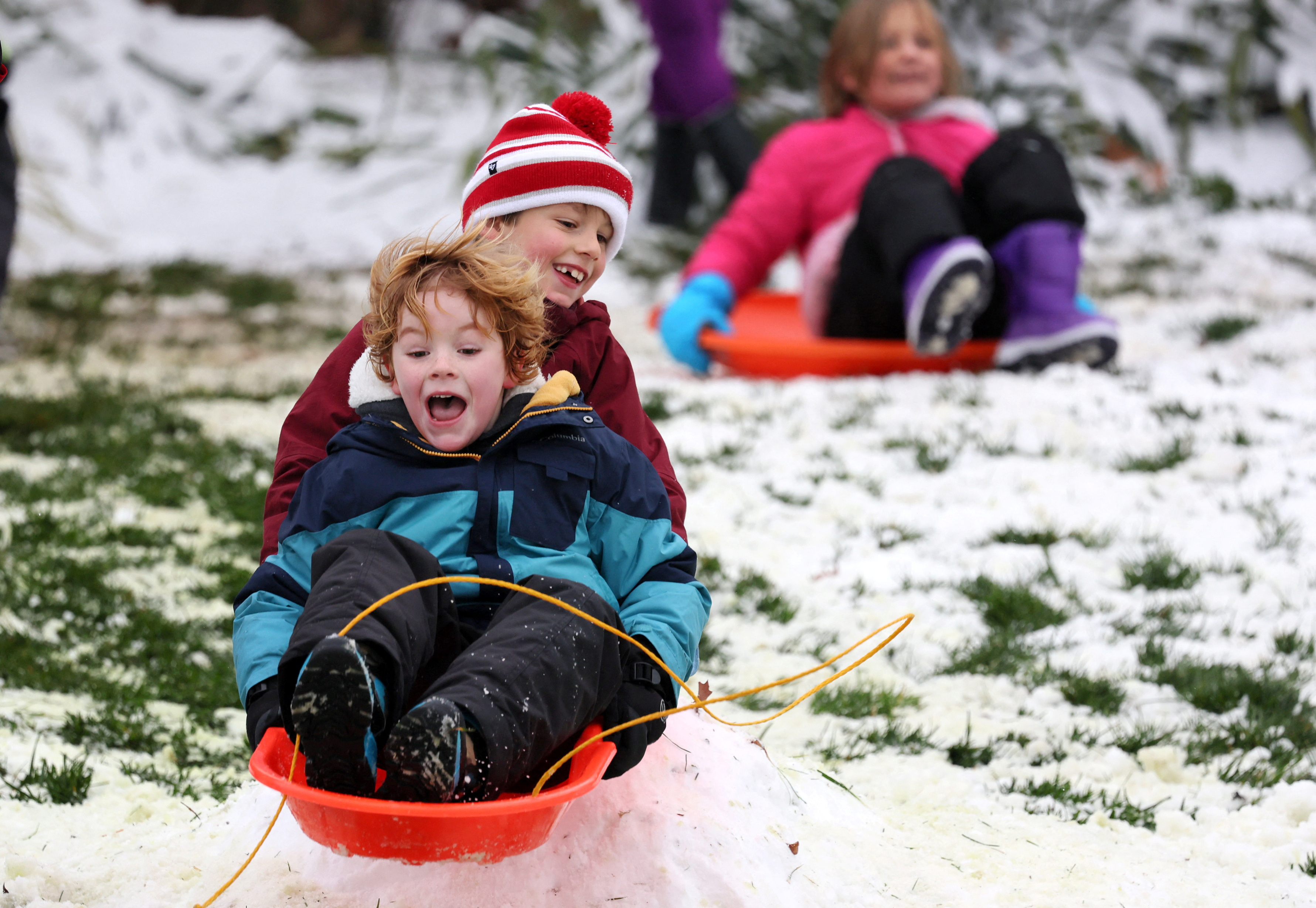 Sebastian, 6 and Henry, 6, react as they catch air while sledding down a hill outside of the U.S. Capitol building in Washington, U.S., January 16, 2024. 