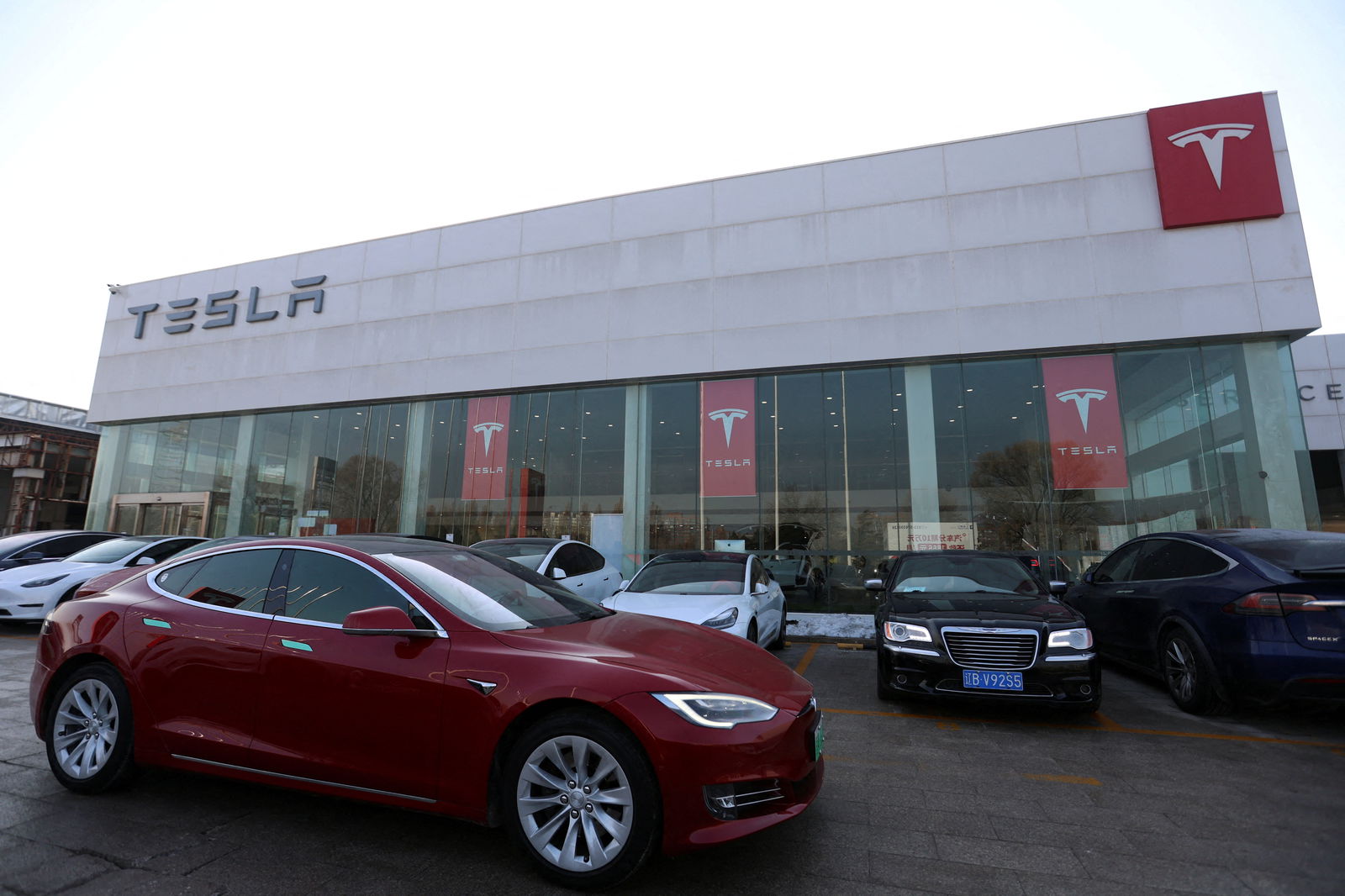 A Tesla car is driven past a dealership of the electric vehicle (EV) maker in Beijing, China January 4, 2024. 