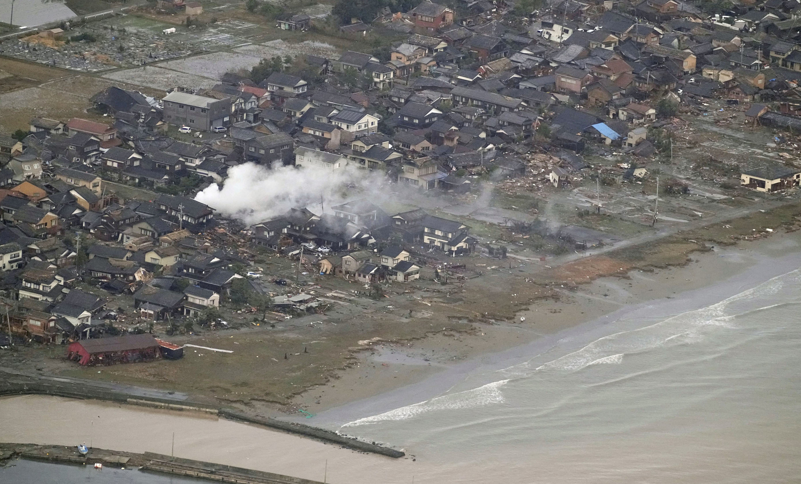 Smoke rises from the destroyed site caused by an earthquake at a residential area in Suzu, Ishikawa prefecture, Japan January 2, 2024, in this photo released by Kyodo. 
