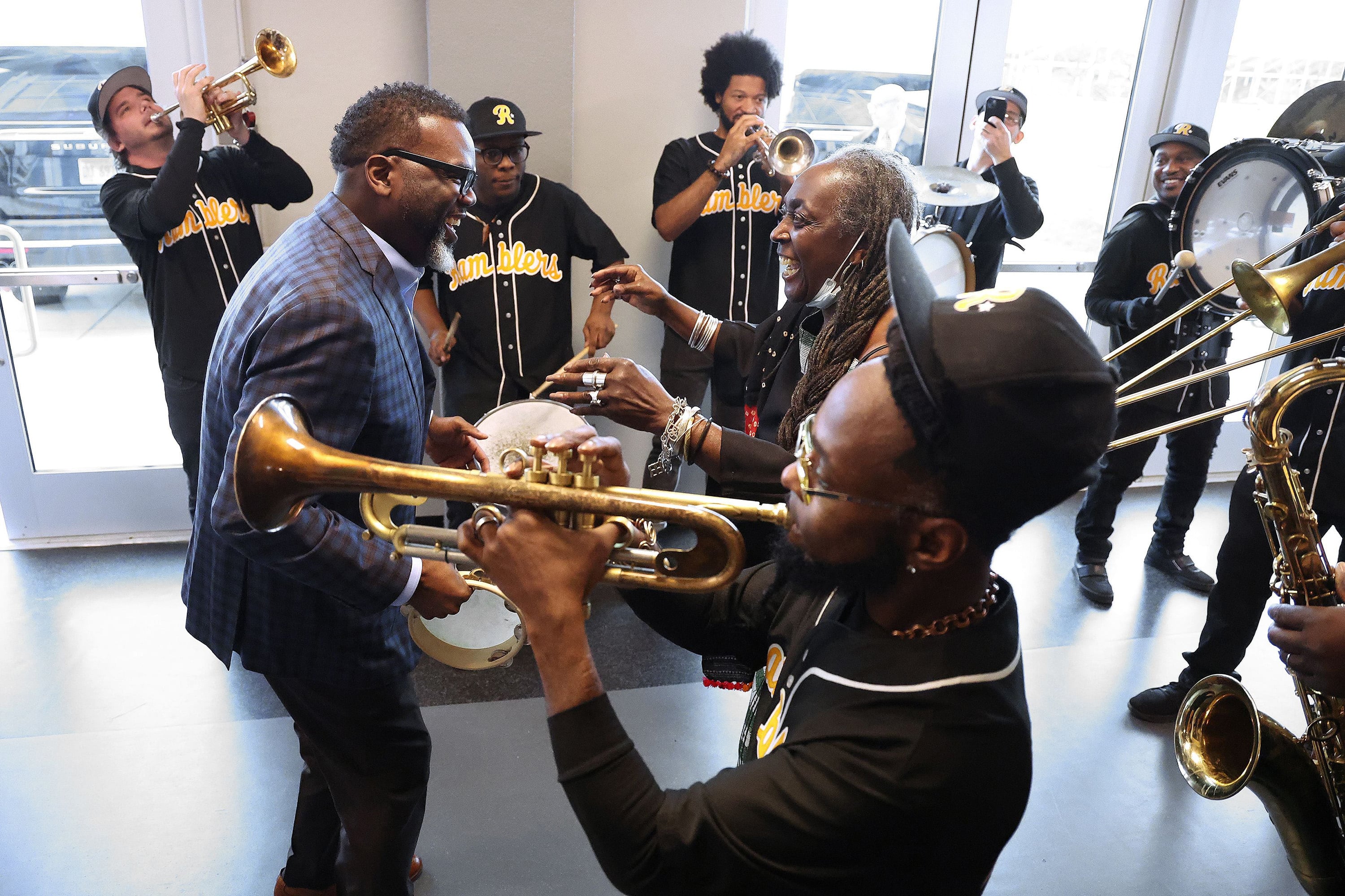 Chicago Mayor Brandon Johnson, left, dances with Alice Smith and plays the tambourine as the Chicago Windy City Ramblers perform at a Kwanzaa celebration at the Conrad Worrill Track & Field Stadium on Dec. 26, 2023. 