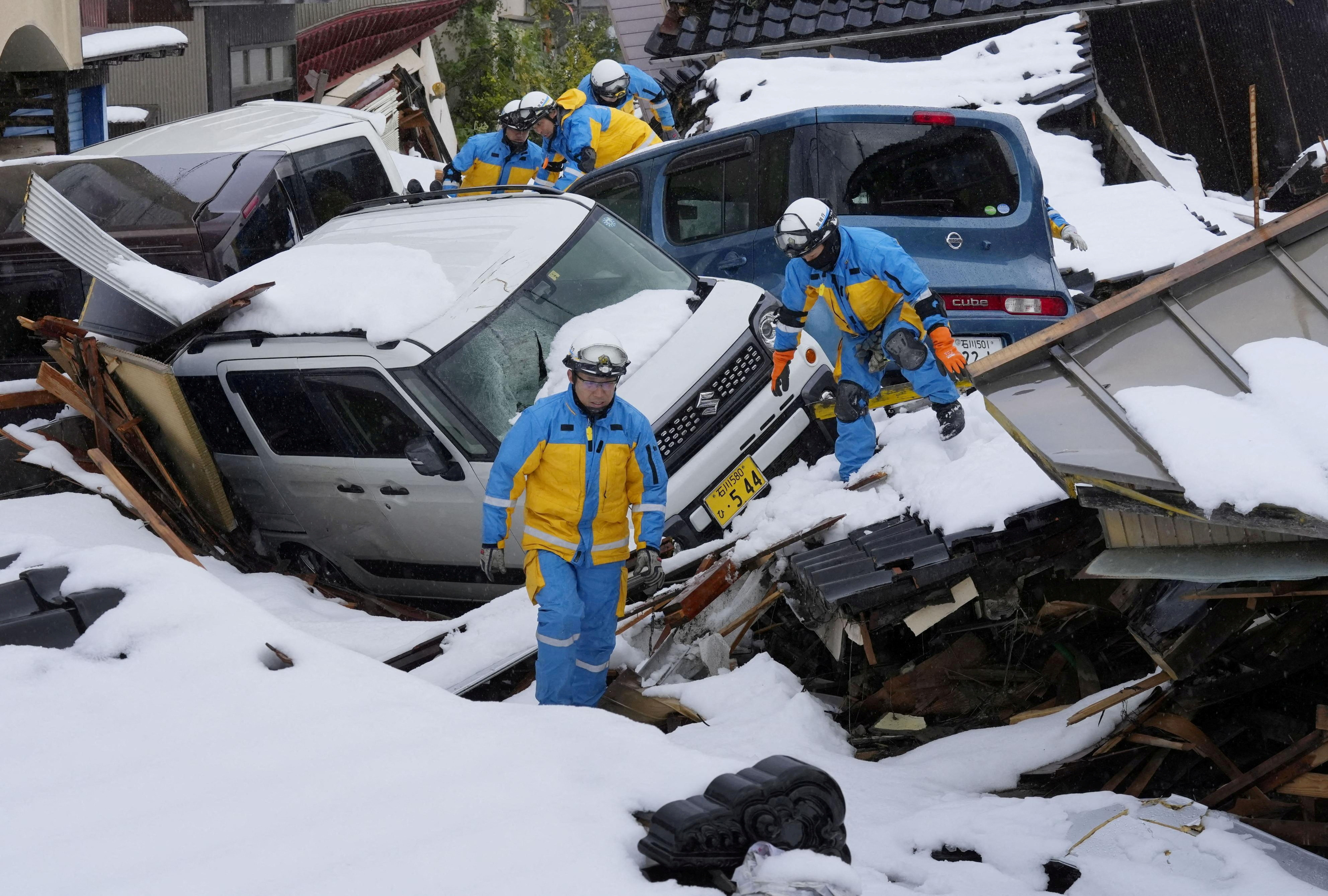 Police officers search for victims in a snow covered residential area which was devastated by a tsunami following an earthquake, in Suzu, Ishikawa Prefecture, Japan, January 9, 2024. 