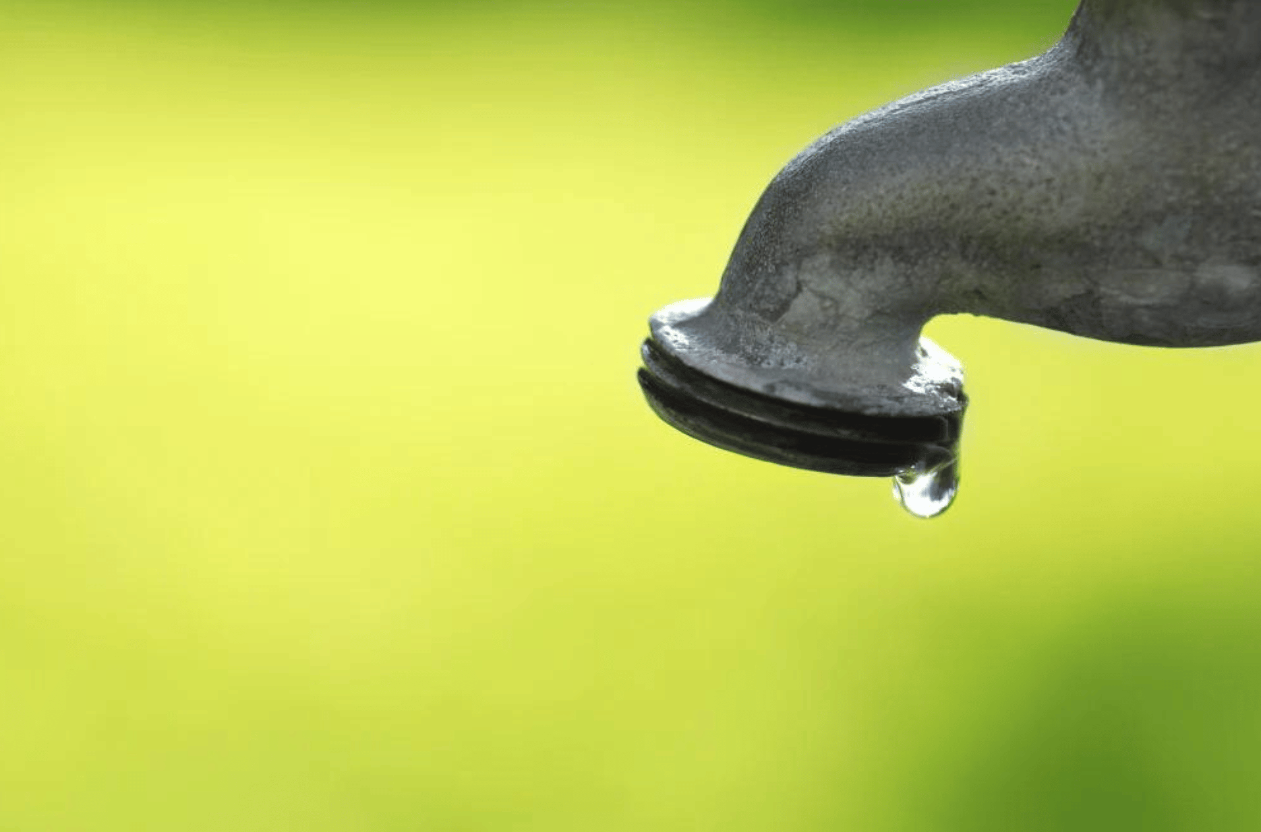 Detail of dripping faucet with water drop.