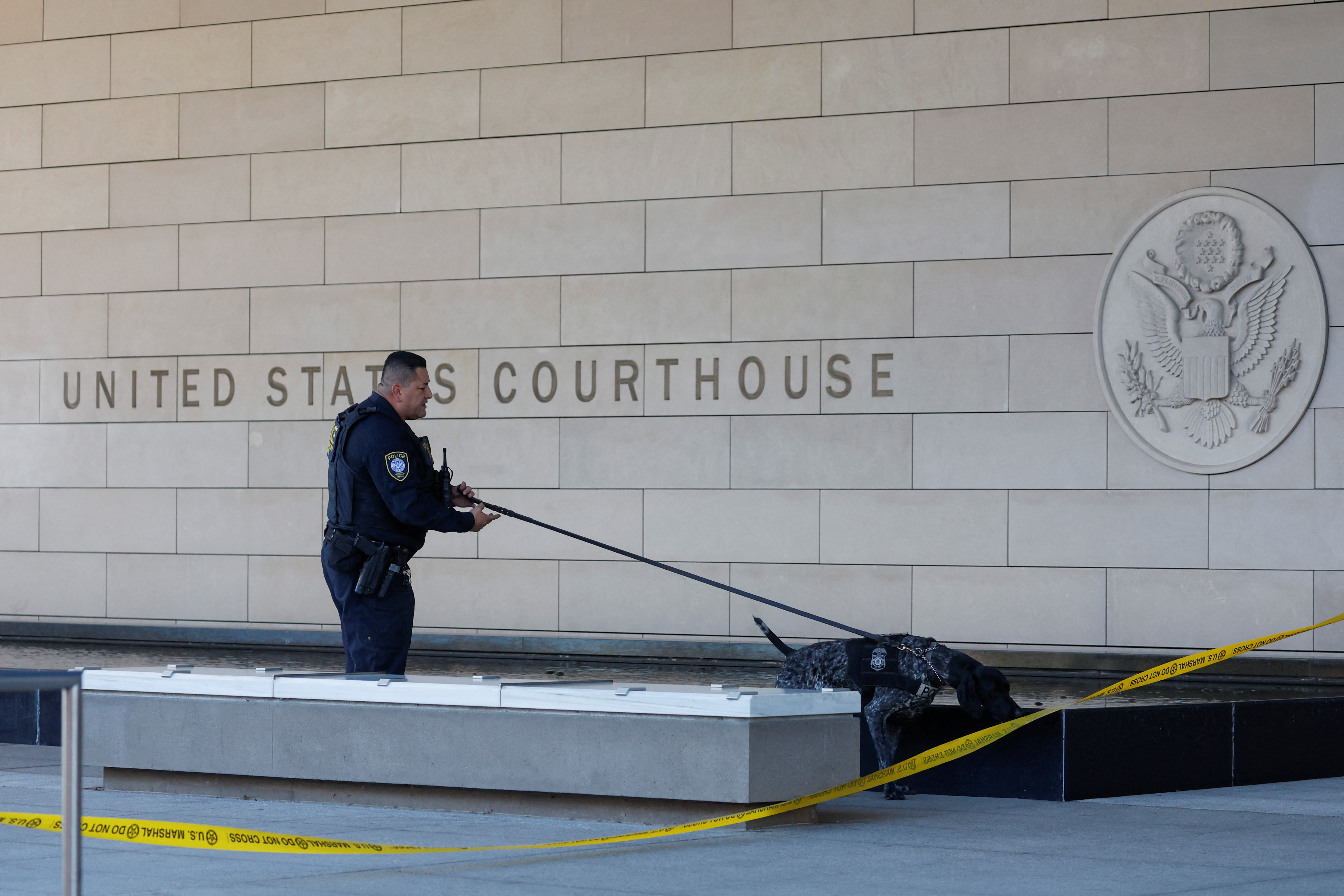 A federal police officer with a dog inspects the area outside a federal court where Hunter Biden, son of U.S. President Joe Biden, is expected to appear on tax charges, in Los Angeles, California, U.S., January 11, 2024. 