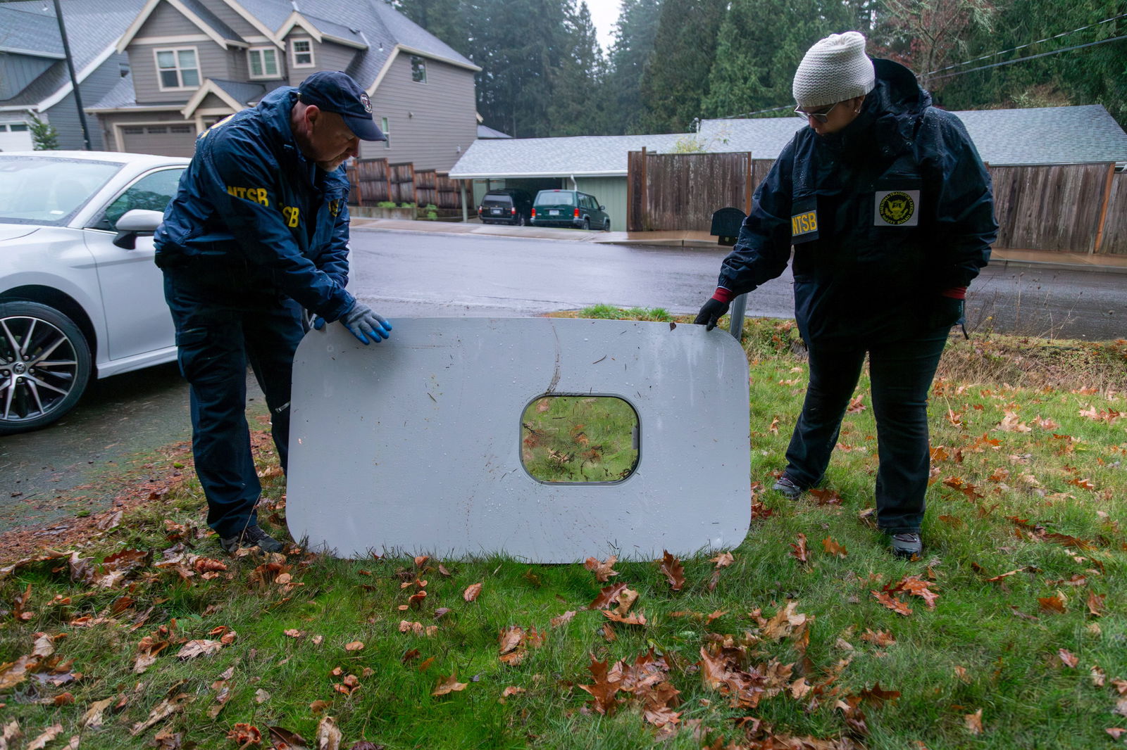 National Transportation Safety Board (NTSB) investigators examine the fuselage plug area of Alaska Airlines Flight 1282 Boeing 737-9 MAX, which was jettisoned and forced the aircraft to make an emergency landing, at a property where it was recovered in Portland, Oregon, U.S. January 8, 2024. 