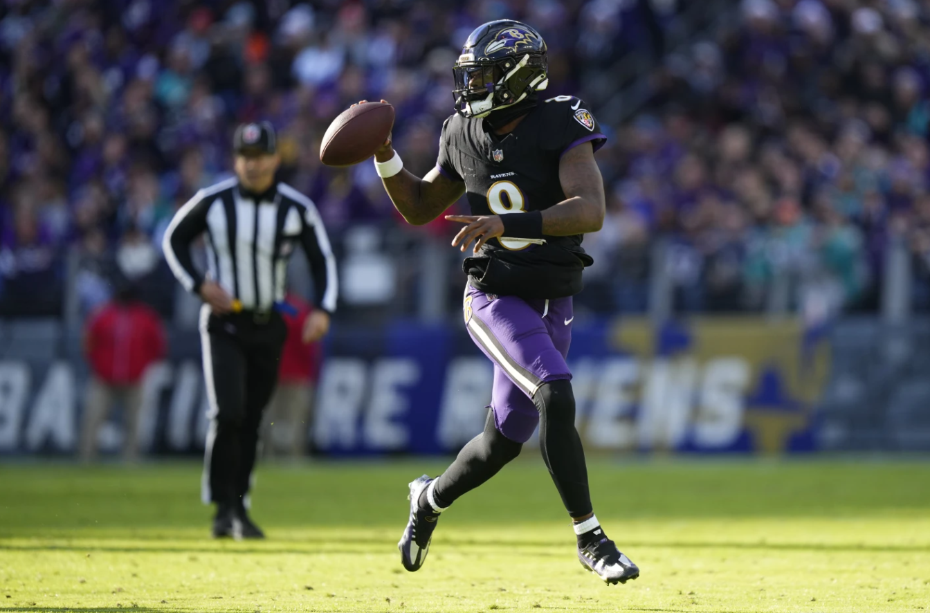Baltimore Ravens quarterback Lamar Jackson looks to pass as he scrambles against the Miami Dolphins during the first half of an NFL game in Baltimore, Sunday, Dec. 31, 2023.