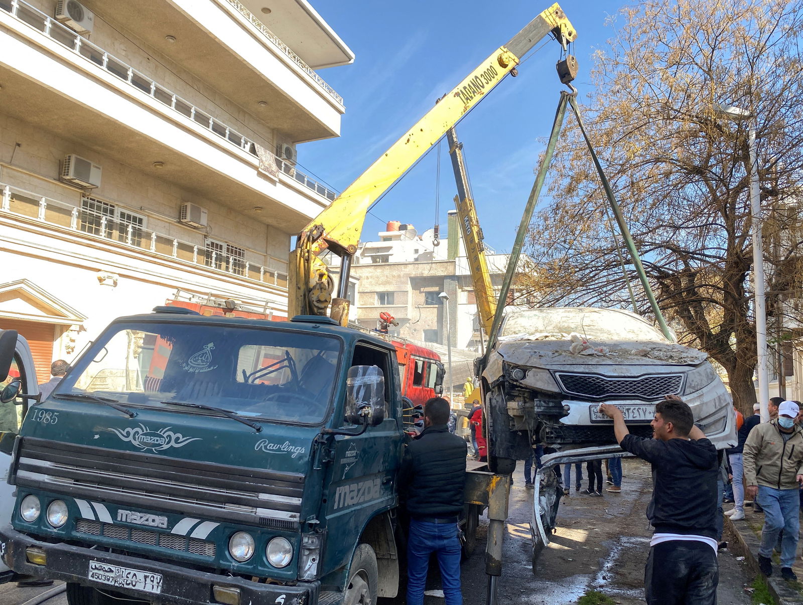 A crane lifts a damaged car near a site that was hit by an Israeli strike according to sources, in the Mazzeh neighborhood of Damascus, Syria January 20, 2024. 