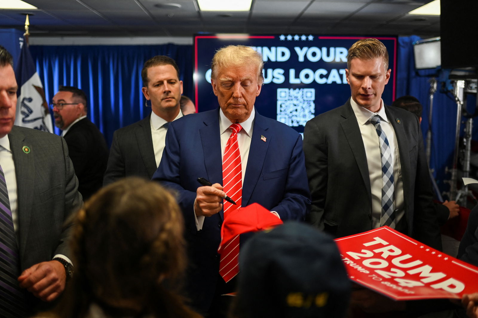 Former U.S. President and Republican presidential candidate Donald Trump signs an autograph as he campaigns in Newton, Iowa, U.S., January 6, 2024. 