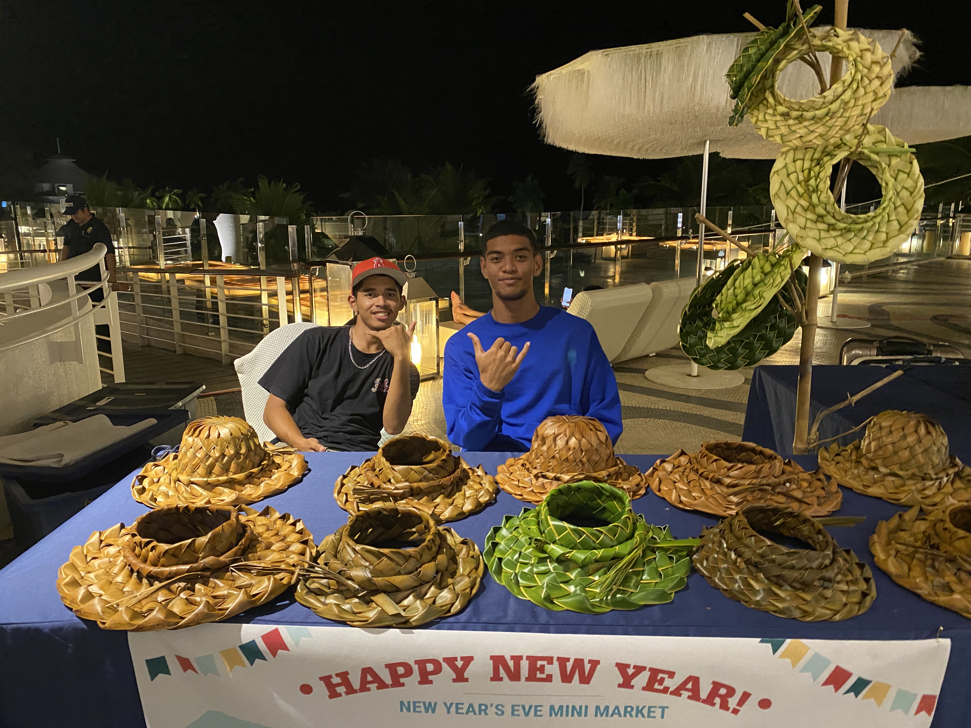 Gerald "Mamis" and Frankie Satur offer handwoven, coconut palm hats for sale.