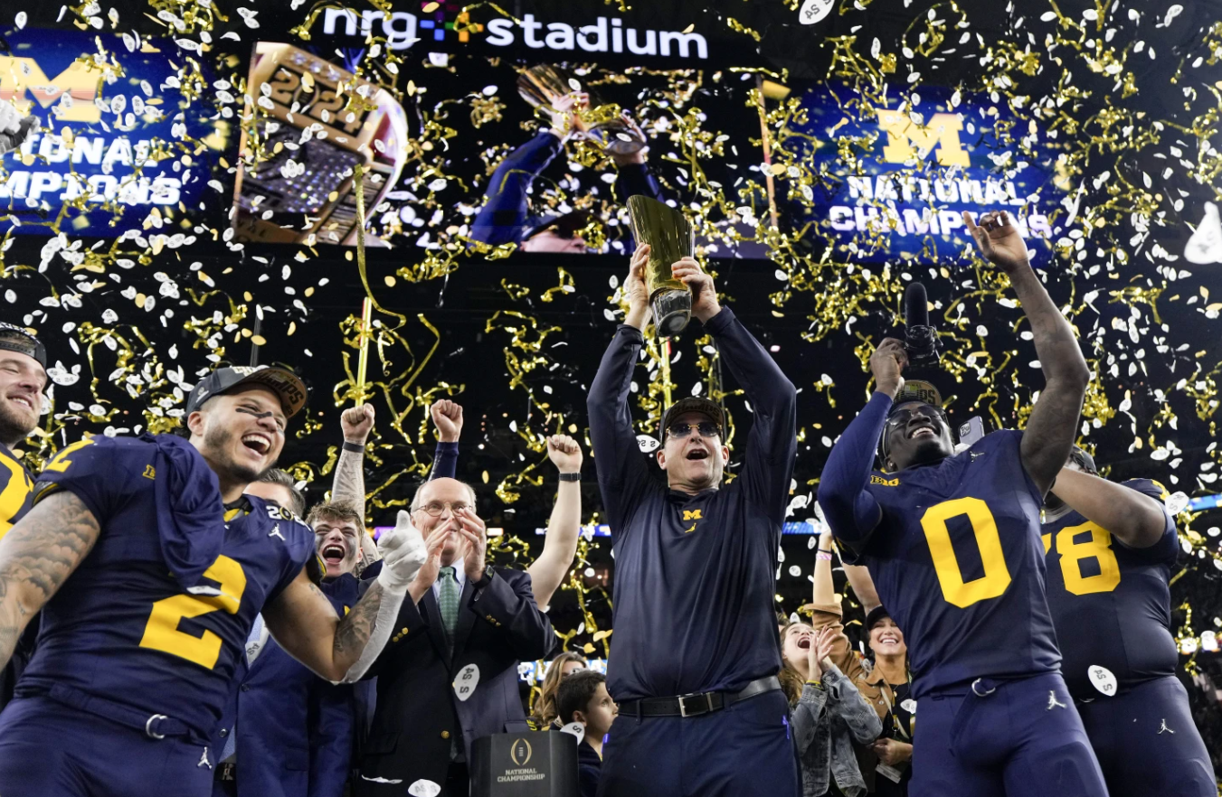 Michigan head coach Jim Harbaugh celebrates with the trophy after their win against Washington in the national championship NCAA College Football Playoff game, Monday, Jan. 8, 2024 in Houston.