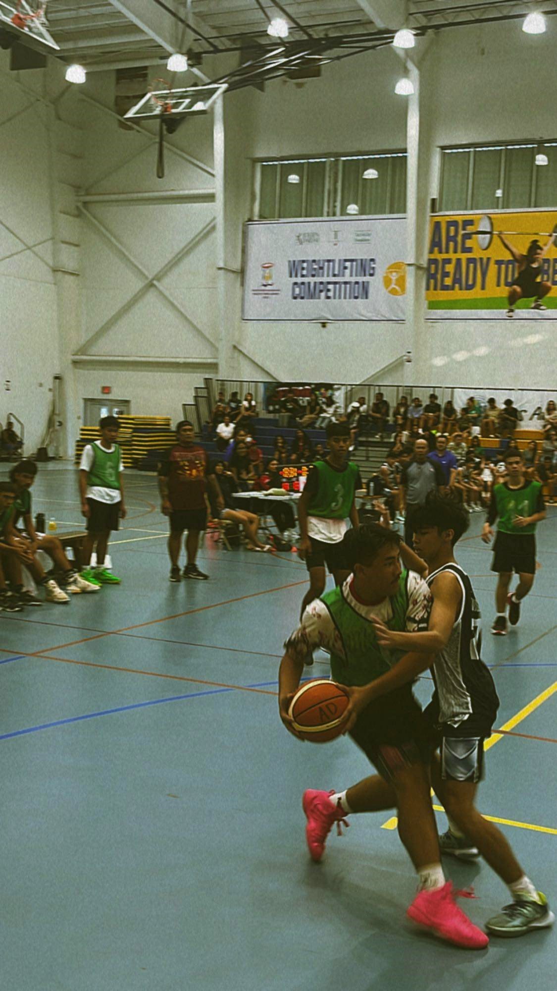 KHS JV's Jericho Pangelinan protects the ball as a defender closes in during a boys high school division game of the IT&E Interscholastic Basketball League SY23-24 at the MHS gym on Monday.