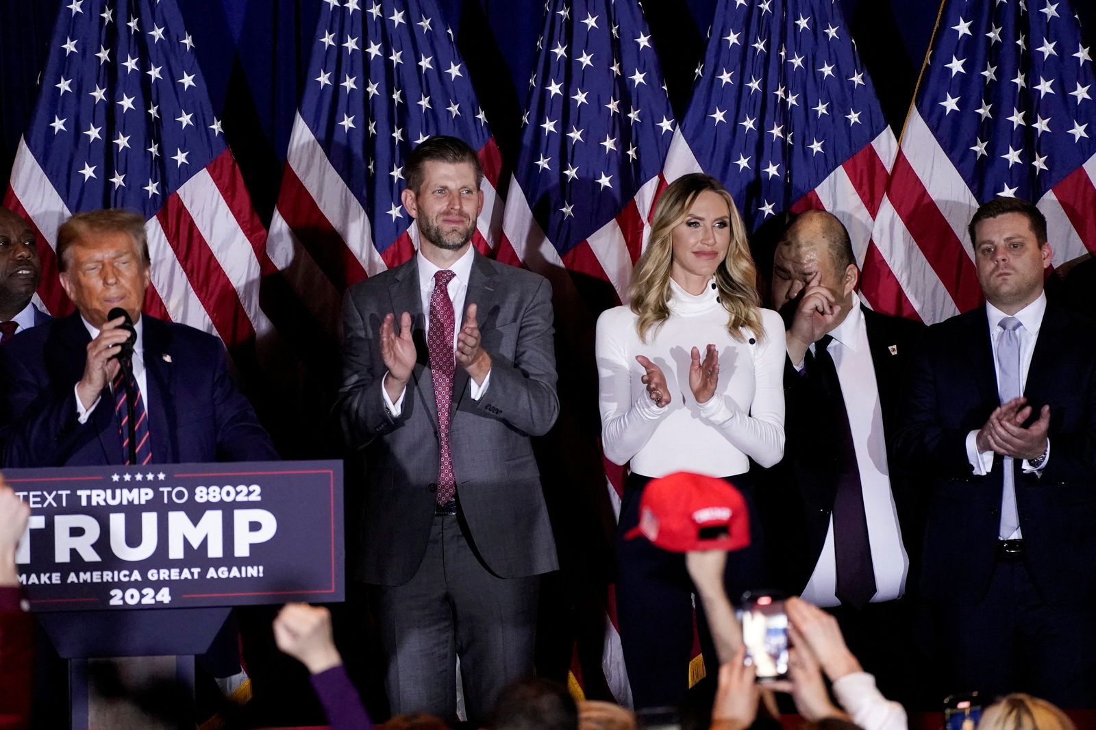 Former U.S. President and Republican presidential candidate Donald Trump speaks on stage, accompanied by his son Eric and daughter-law Lara, during a New Hampshire presidential primary election night watch party, in Nashua, New Hampshire, U.S., January 23, 2024. 