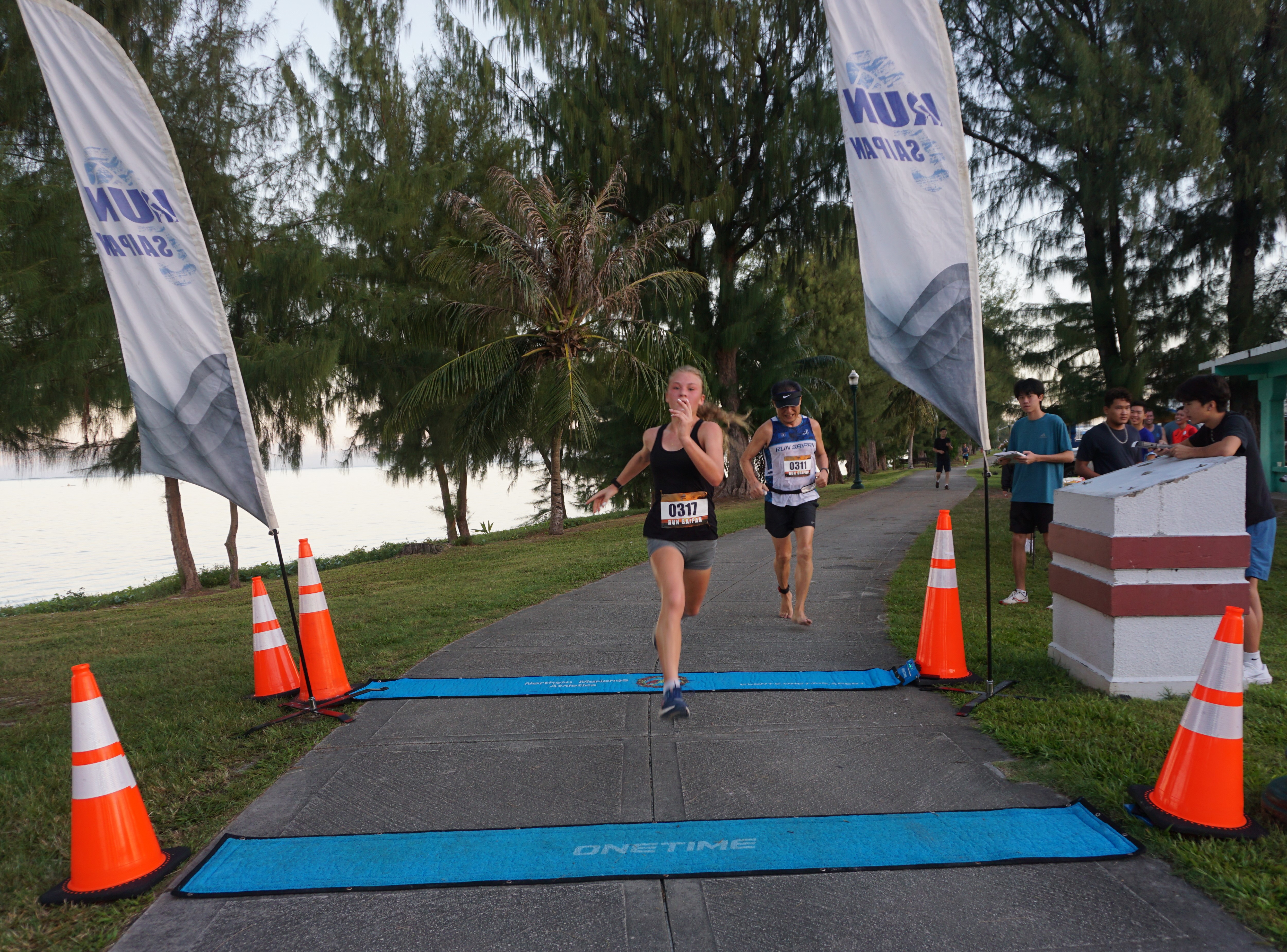 Addalee Taflinger reaches the finish line of the 10K distance race on day 1 of the 2nd Annual Run Saipan Trinity at the Beach Road pathway on Saturday. 