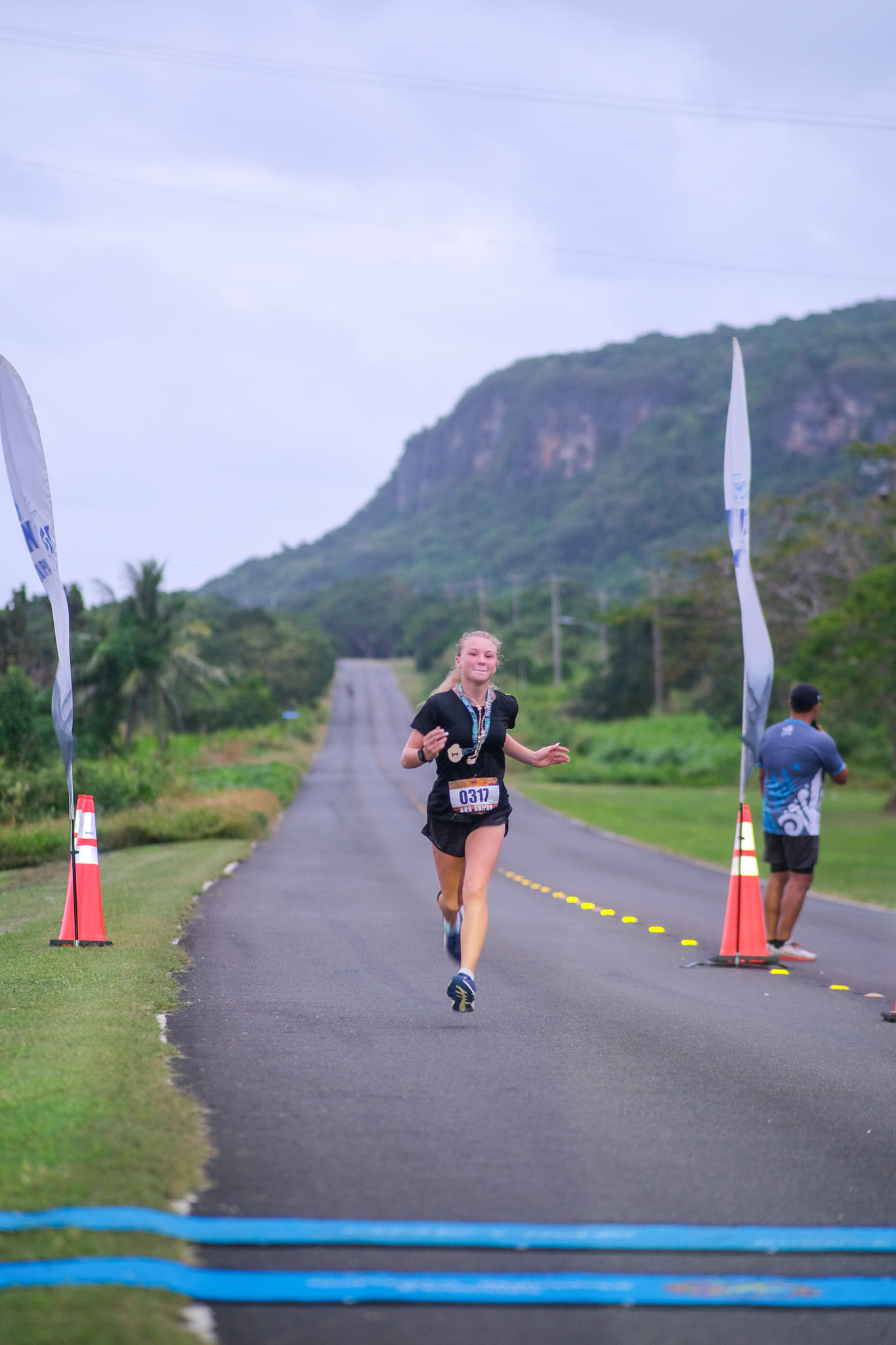 Addalee Taflinger smiles as she crosses the finish line on day 3 of the 2nd Annual Run Saipan Trinity in Marpi on Monday.