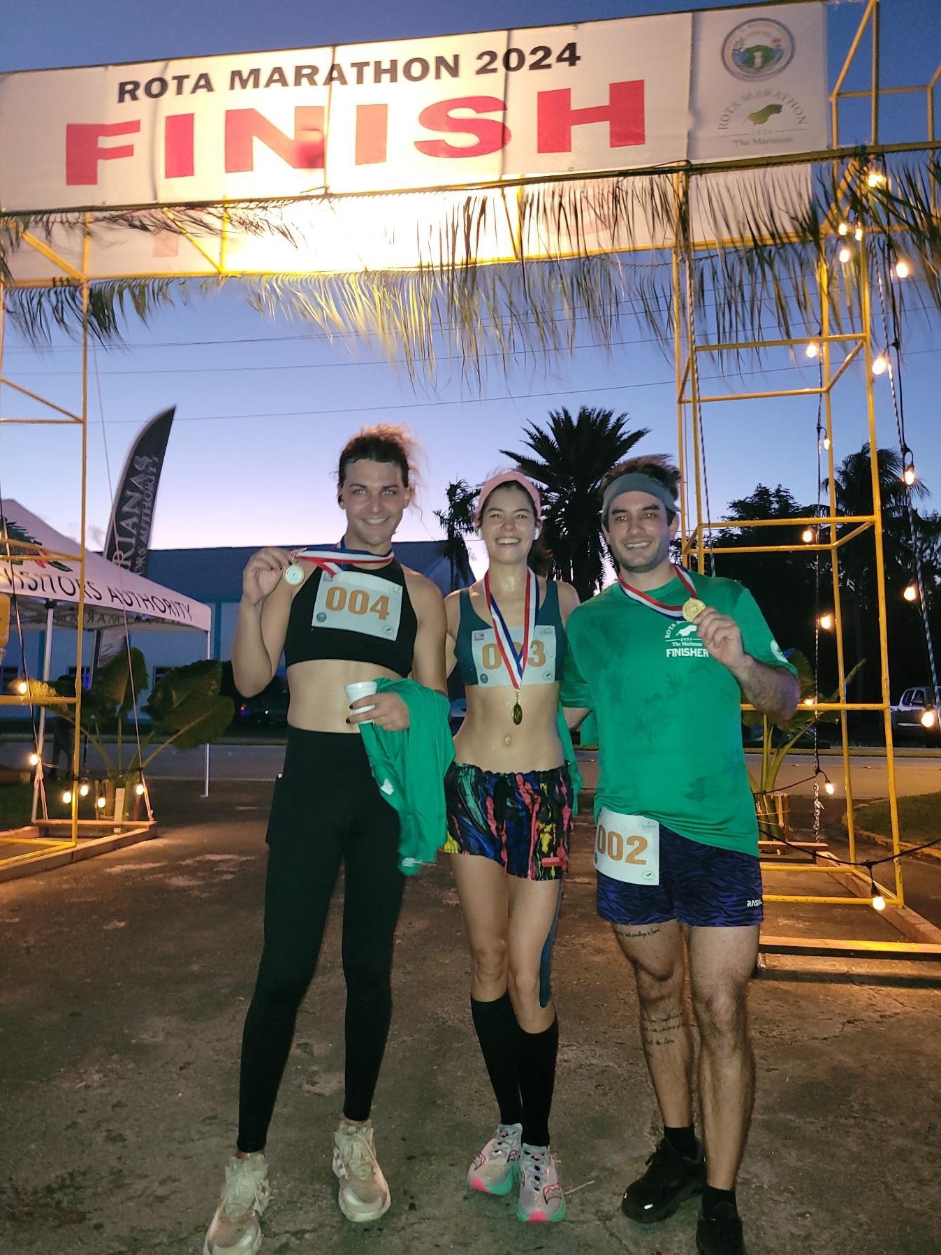 From left, Dominic Kieffer, Tammy Ackerman, and Scott Smith celebrate their winning half- marathon finishes at Rota Marathon 2024 on Jan. 13, 2024.  The trio won 1st place men’s division, 1st place women’s division, and 2nd place men’s division, respectively.