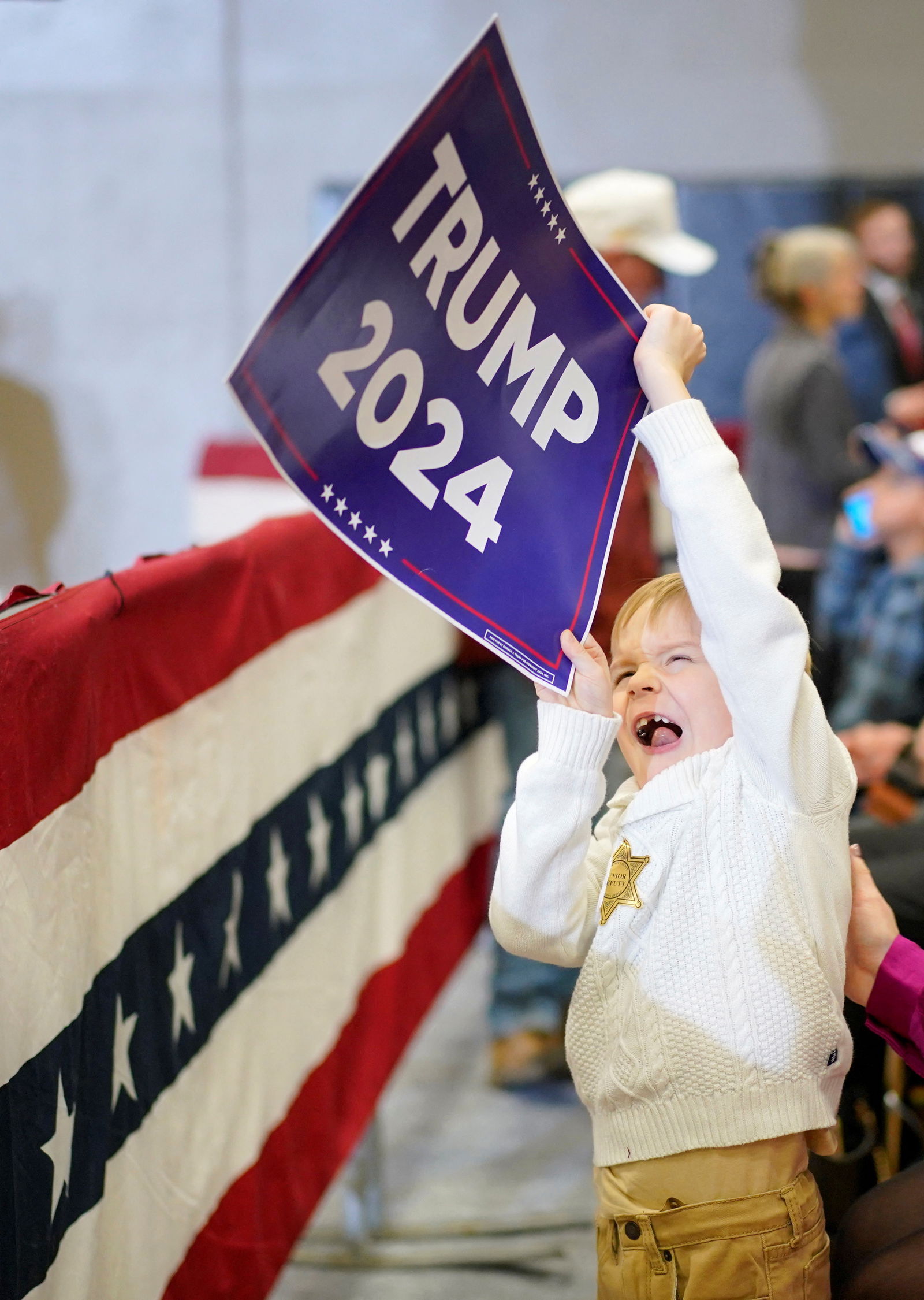 A child reacts as supporters attend a campaign event held by former U.S. President and Republican presidential candidate Donald Trump, in Clinton, Iowa, U.S., January 6, 2024. 