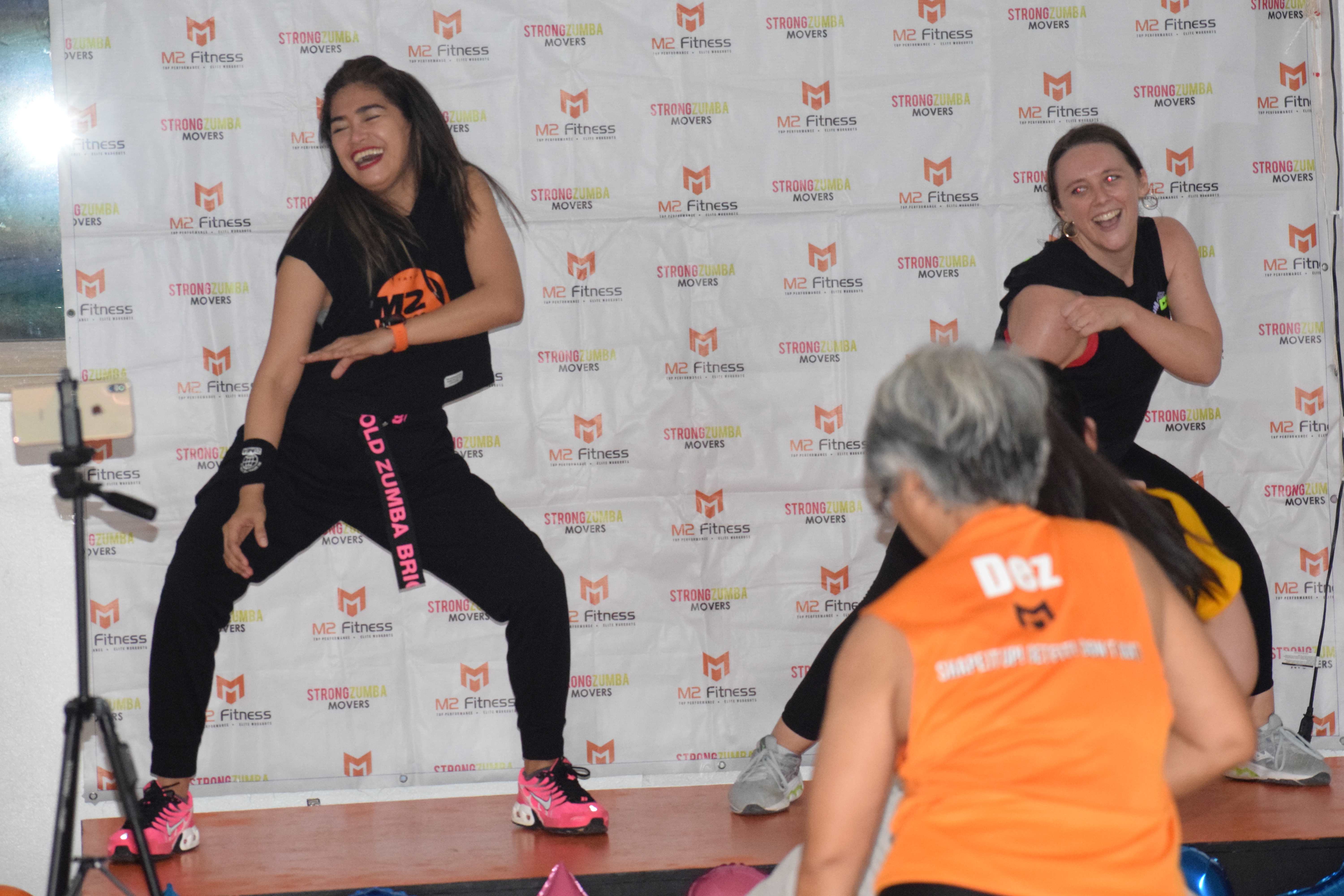 Mary Grace Bautista, left, Julie Harrison, right, and Dez Calayo, back to the camera, perform Zumba moves during a sendoff session.