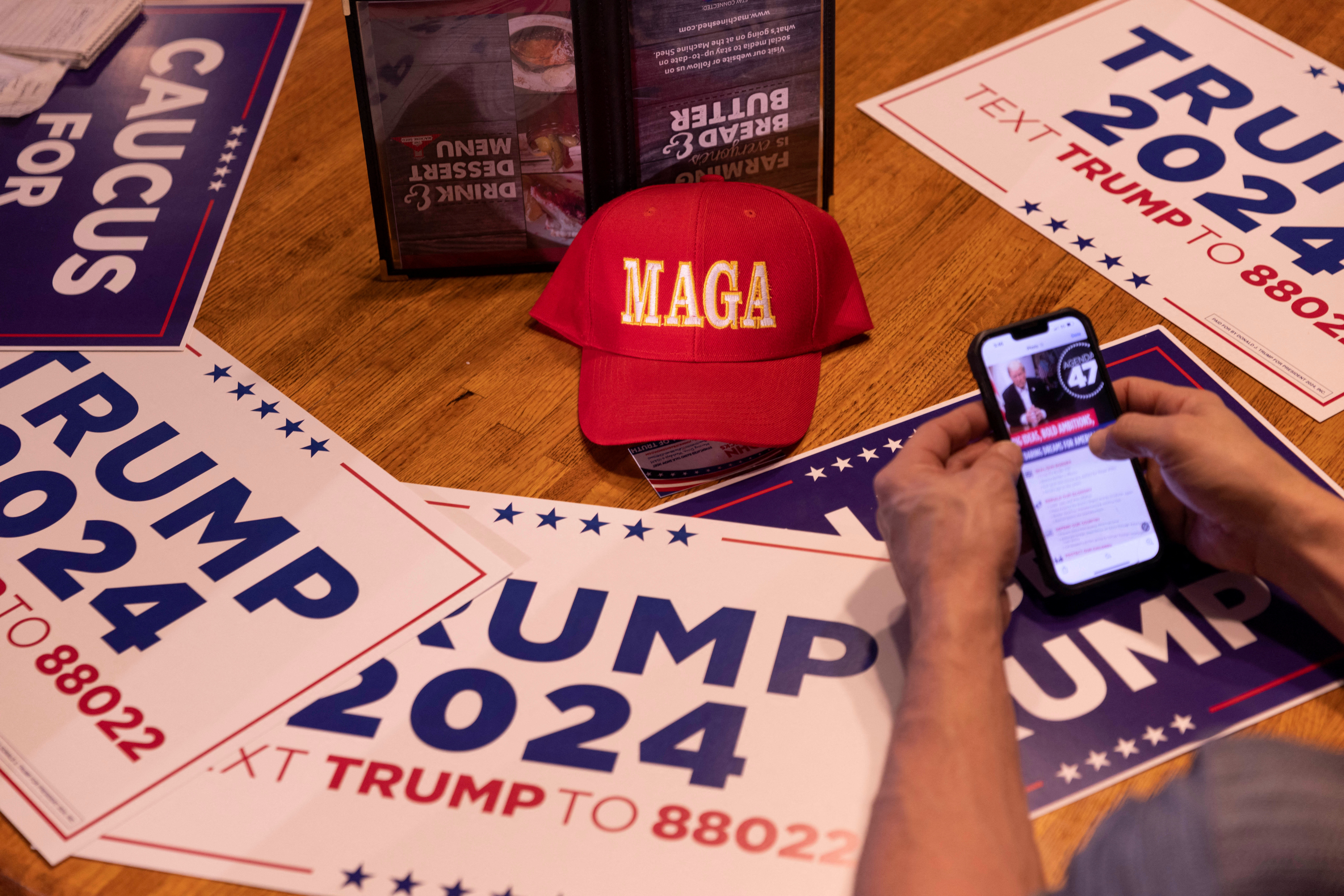 Campaign signs are displayed on a table during an event for Republican presidential candidate and former U.S. President Donald Trump at the Machine Shed Restaurant ahead of the Iowa caucus vote where he is seeking the nomination as Republican presidential candidate in Urbandale, Iowa, U.S., January 11, 2024. 