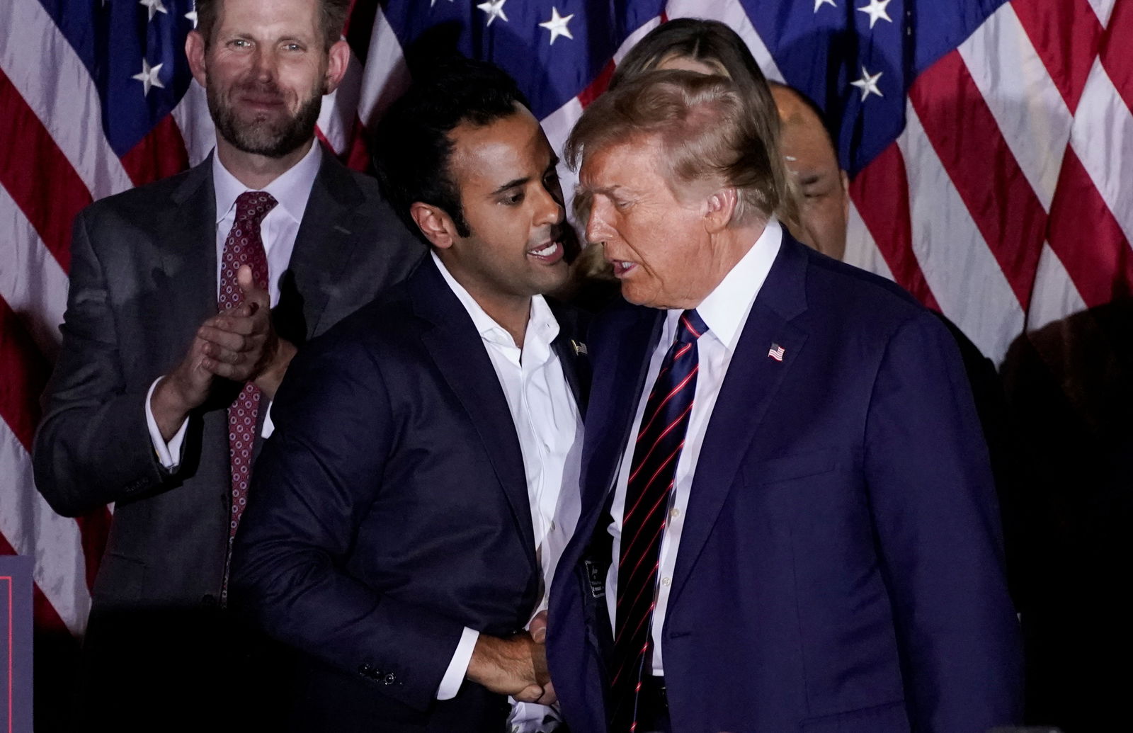 Vivek Ramaswamy, who ended his Republican presidential campaign, greets former U.S. President and Republican presidential candidate Donald Trump on stage during a New Hampshire presidential primary election night watch party, in Nashua, New Hampshire, U.S., January 23, 2024. 
