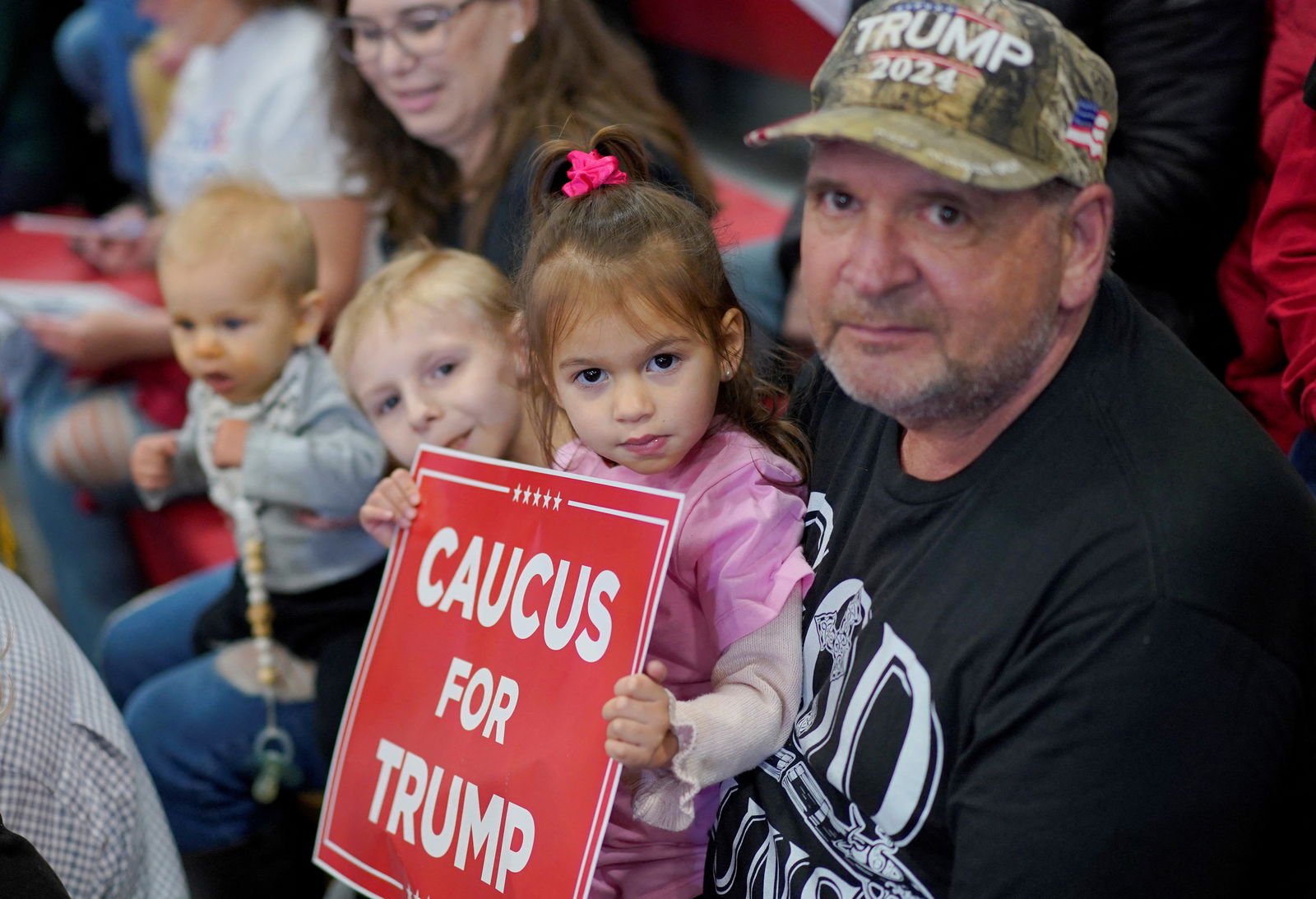 A child holds a plackard as supporters attend a campaign event held by former U.S. President and Republican presidential candidate Donald Trump, in Clinton, Iowa, U.S., January 6, 2024. 