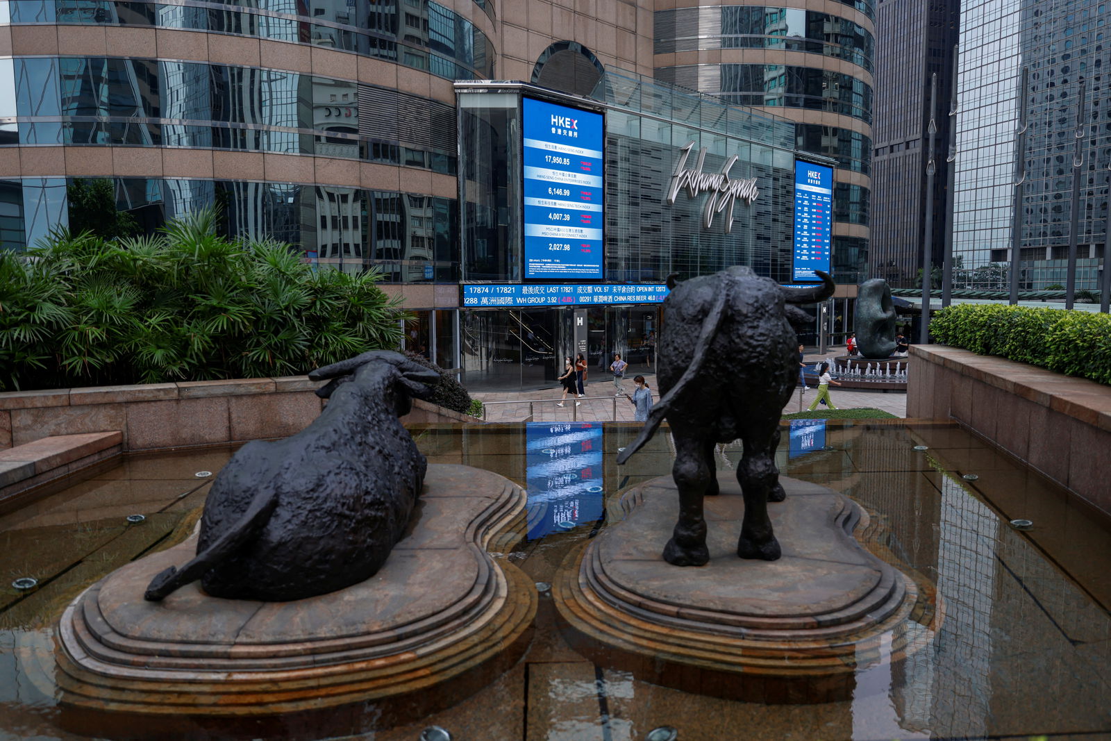 Bull statues are placed in font of screens showing the Hang Seng stock index and stock prices outside Exchange Square, in Hong Kong, China, Aug. 18, 2023.