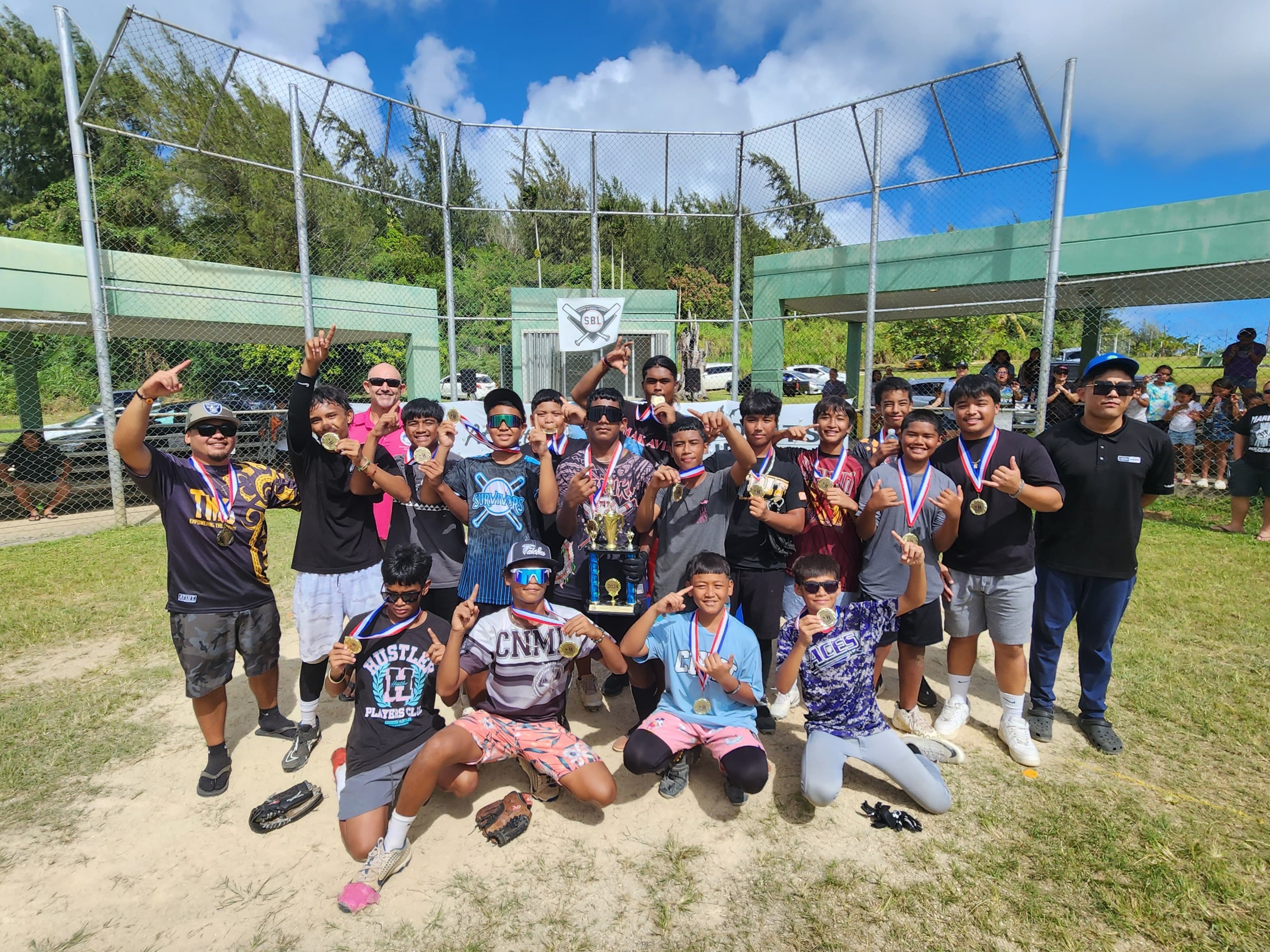 The Tanapag Middle School players pose for a photo with the boys middle school division championship trophy of the SBL-PSS Interscholastic Softball League SY23-24 at the Capital Hill baseball field on Saturday.