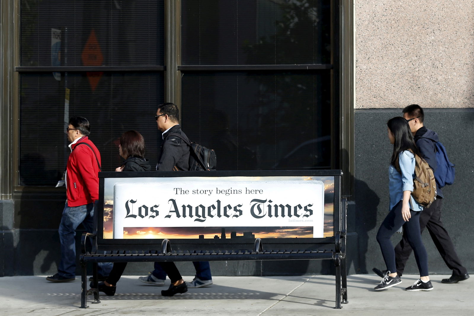 People walk past the building of Los Angeles Times newspaper, which is owned by Tribune Publishing Co, in Los Angeles, California, U.S., April 27, 2016. 