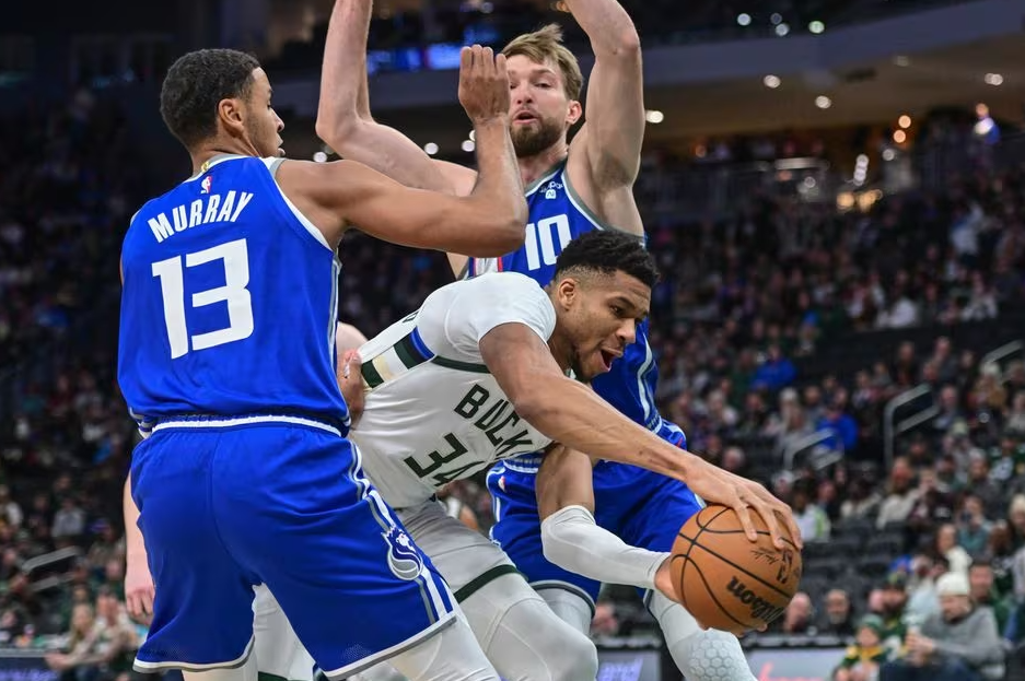 Milwaukee Bucks forward Giannis Antetokounmpo (34) gets pressure from Sacramento Kings forward Keegan Murray (13) and center Domantas Sabonis (10) in the first quarter at Fiserv Forum in Milwaukee, Wisconsin, Jan. 14, 2024.