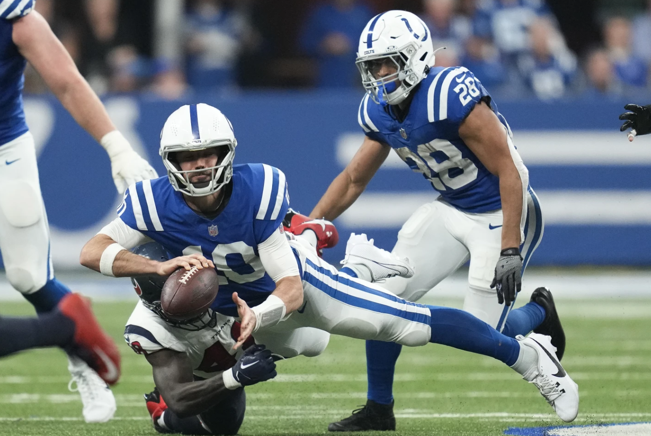 Indianapolis Colts quarterback Gardner Minshew (10) is tackled by Houston Texans linebacker Christian Harris (48) during the first half of an NFL game Saturday, Jan. 6, 2024, in Indianapolis.