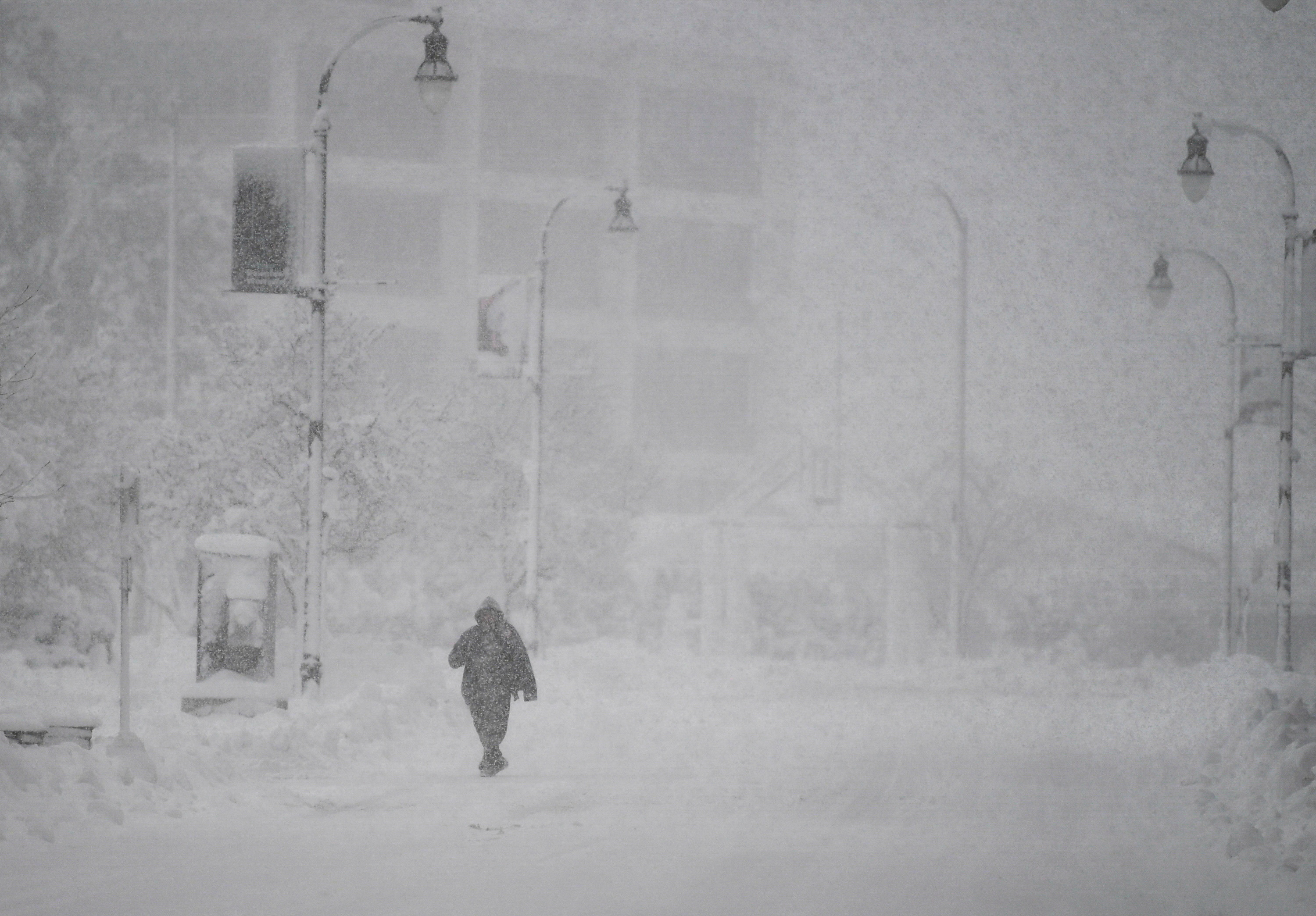 A person walks across the empty street during the first winter storm of 2024 which is expected to bring heavy snowfall across the northeast United States, in Worcester, Massachusetts, U.S. January 7, 2024. 