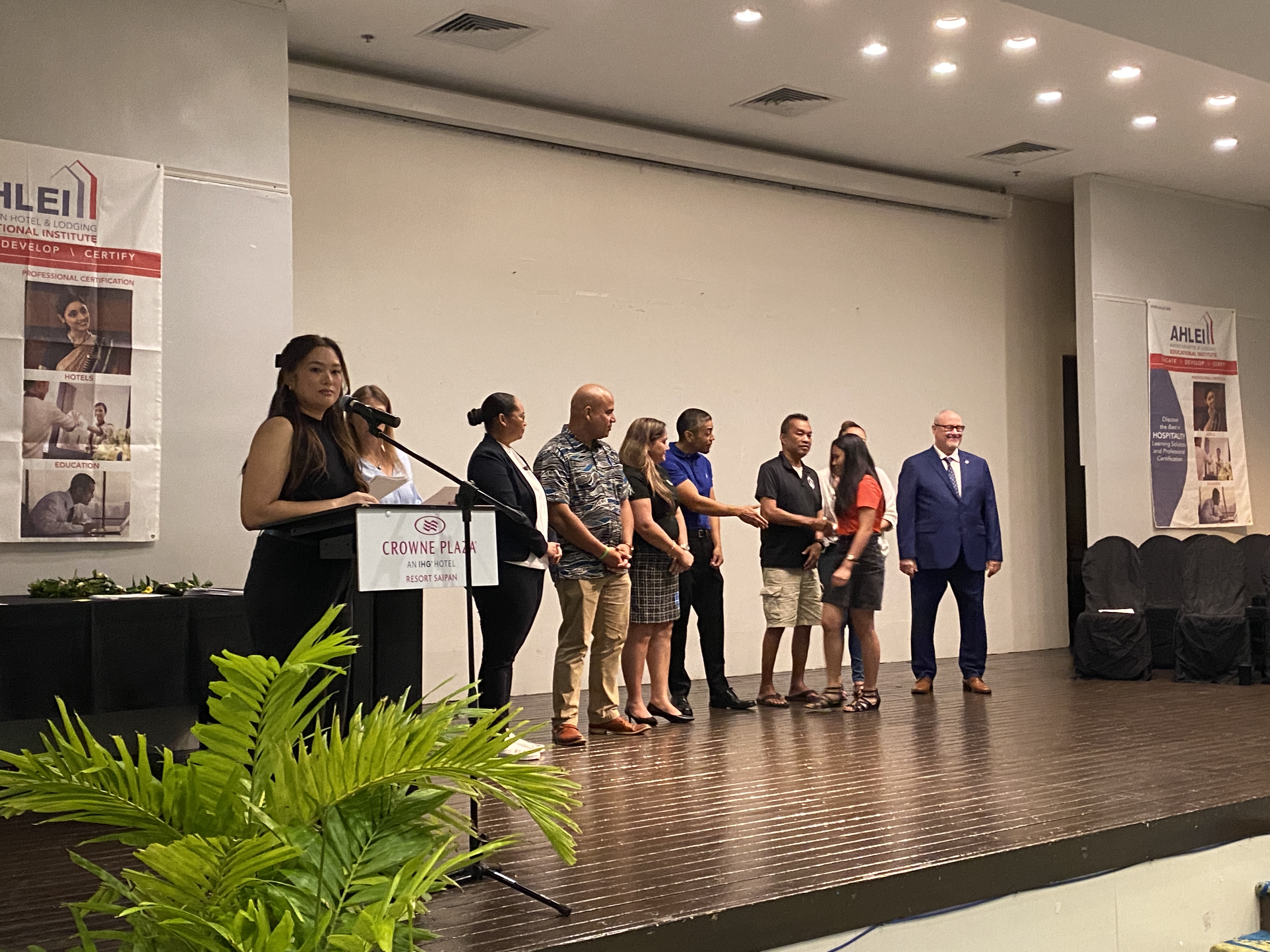 A Public School System student shakes hands with stakeholders on her way to receiving her American Hotel and Lodging Educational Institute certificate as part of completing the Trading Up: Hospitality course on Thursday, Feb. 8.