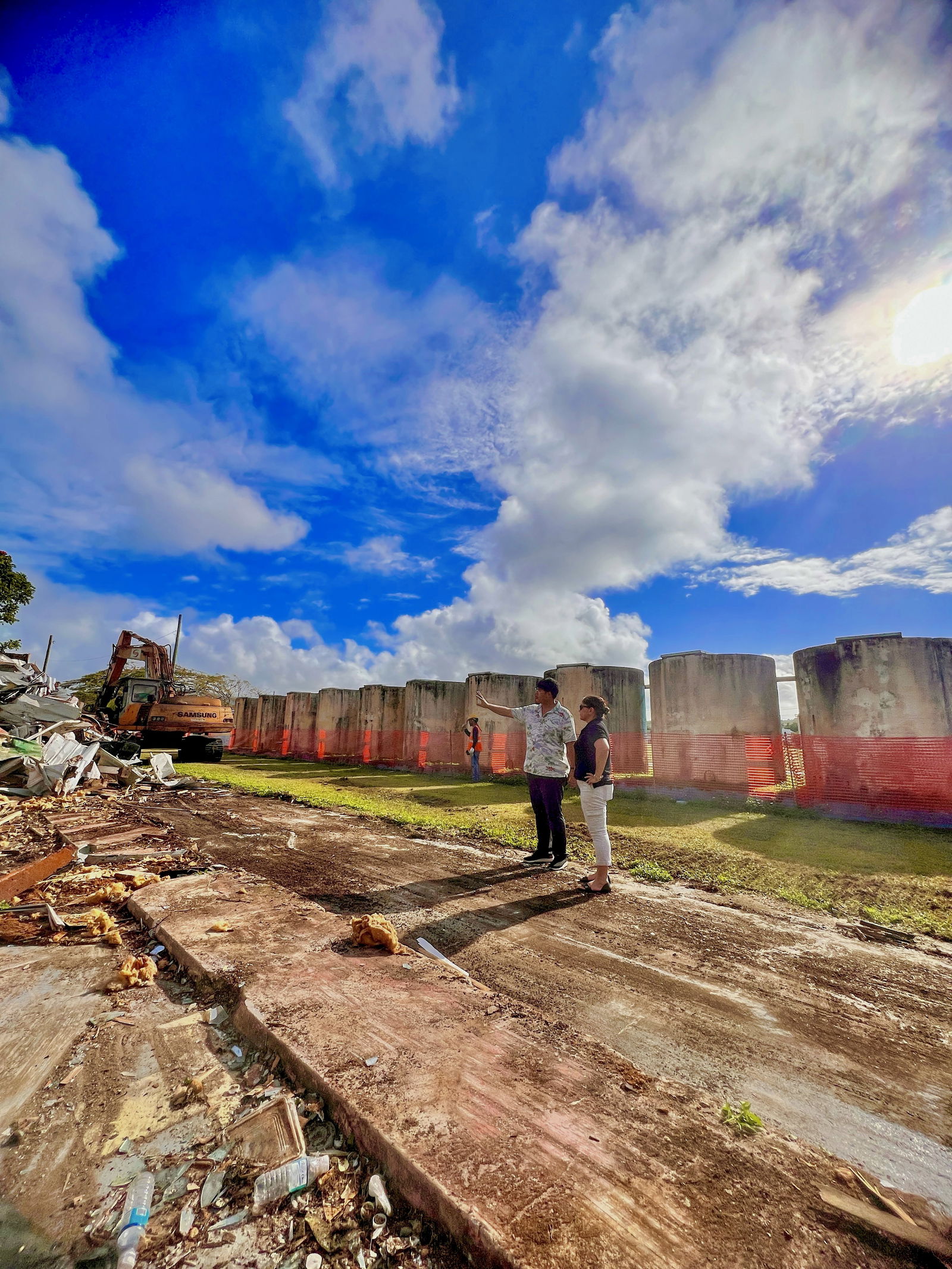 Acting Commissioner of Education Donna M. Flores, right, is briefed by FSM Recycling Corporation's Michael Jang, left, regarding the demolition of Hopwood’s condemned buildings on Saturday.