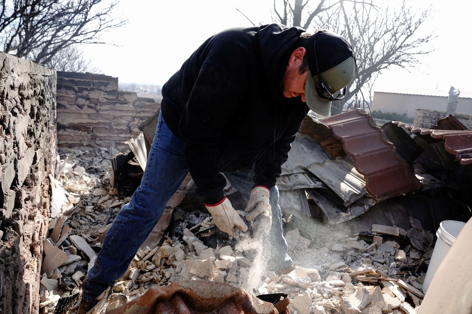 Mason Holloway sifts through the remains of his aunts home that was destroyed by the Smokehouse Creek wildfire, in Canadian, Texas, U.S., February 28, 2024.