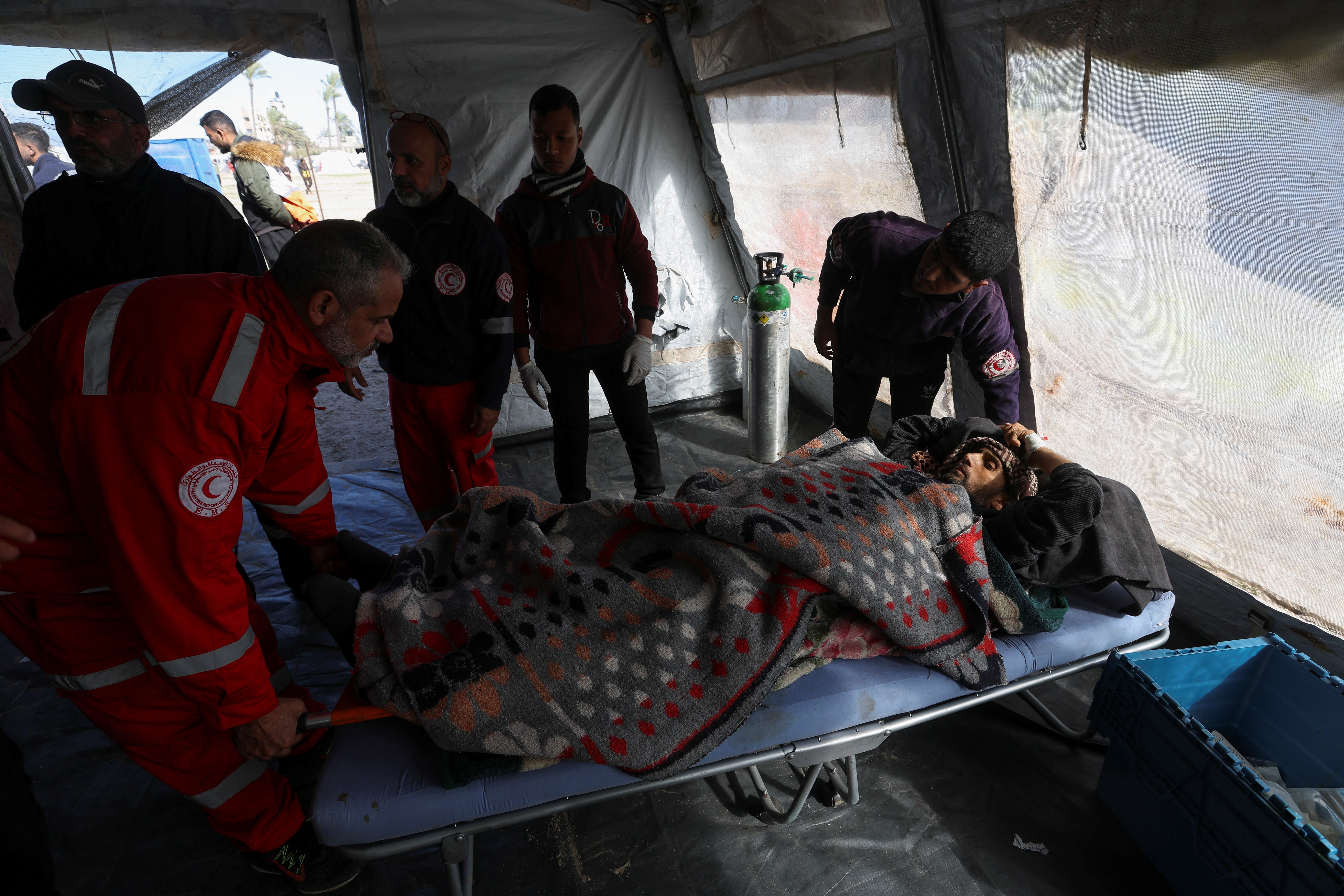Medics help a Palestinian man, wounded in Israeli fire, at a medical point formed to get better access to frontlines, amid the ongoing conflict between Israel and Hamas, in Khan Younis in the southern Gaza Strip January 30, 2024. 