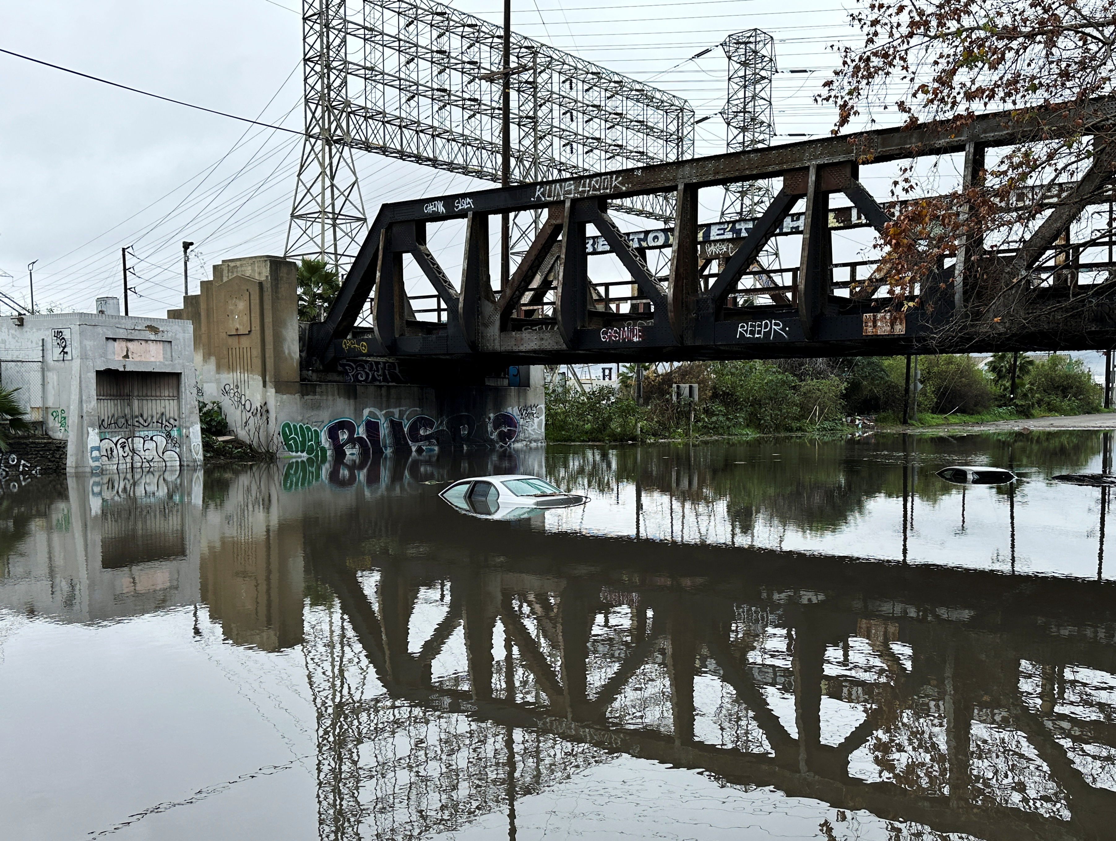 Cars lie partially submerged in water, as the first in a pair of Pacific storms floods parts of Southern California, in Long Beach, California, February 1, 2024. 