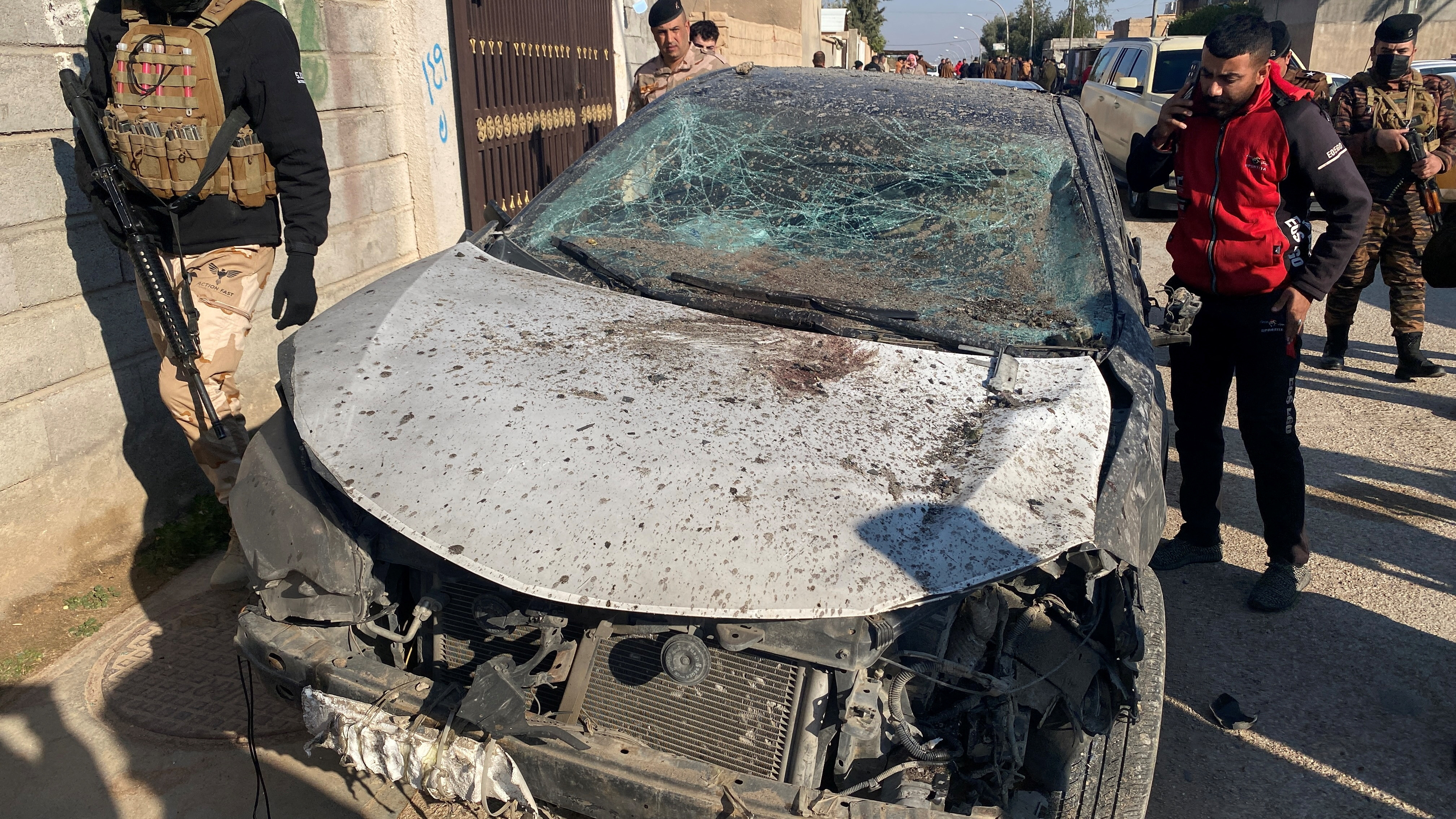 Security forces inspect a damaged car at the site of a U.S. airstrike in al-Qaim, Iraq February 3, 2024. 
