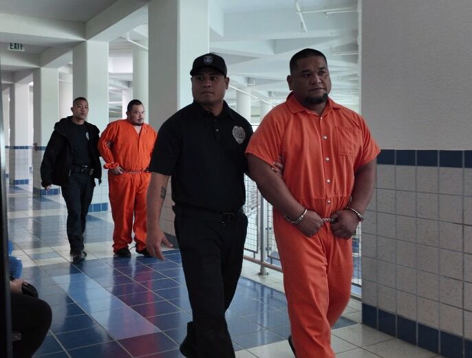 Calvin Tagabuel, right, is escorted by a Corrections officer at the local courthouse on Wednesday morning. Photo also shows another defendant, Kevin Sanchez, background.