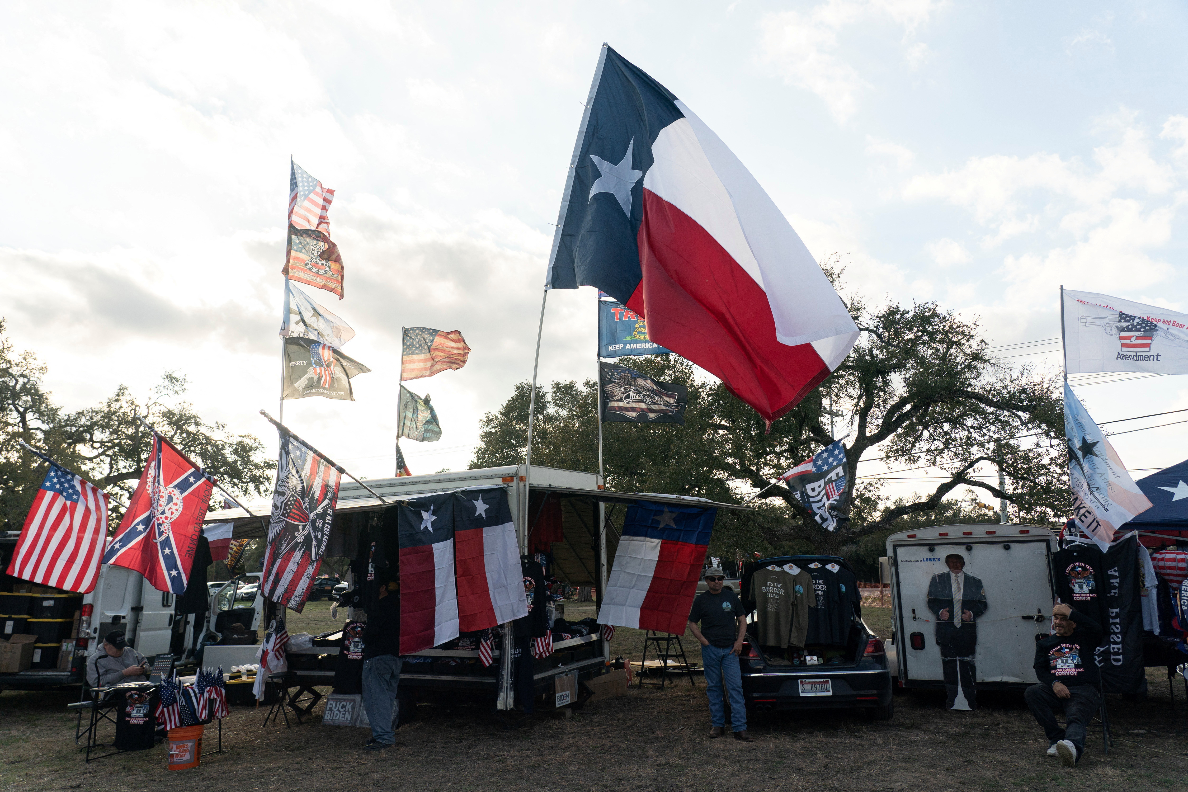 Vendors sell Texas and American flags at a rally hosted by the 'Take Back Our Border' trucker convoy against migrants crossing from Mexico, in Dripping Springs, Texas, U.S., February 1, 2024. 