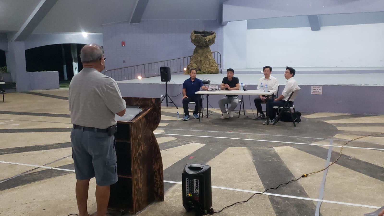Bibong Holdings Chief Executive Officer Bongheung Lee, background center, with Global One Asset Management Senior Advisor Sungjin Hahn and Executive Director Jongjin Kim listen to a question from a Rota resident, back to the camera, on Thursday at the Songsong Roundhouse.