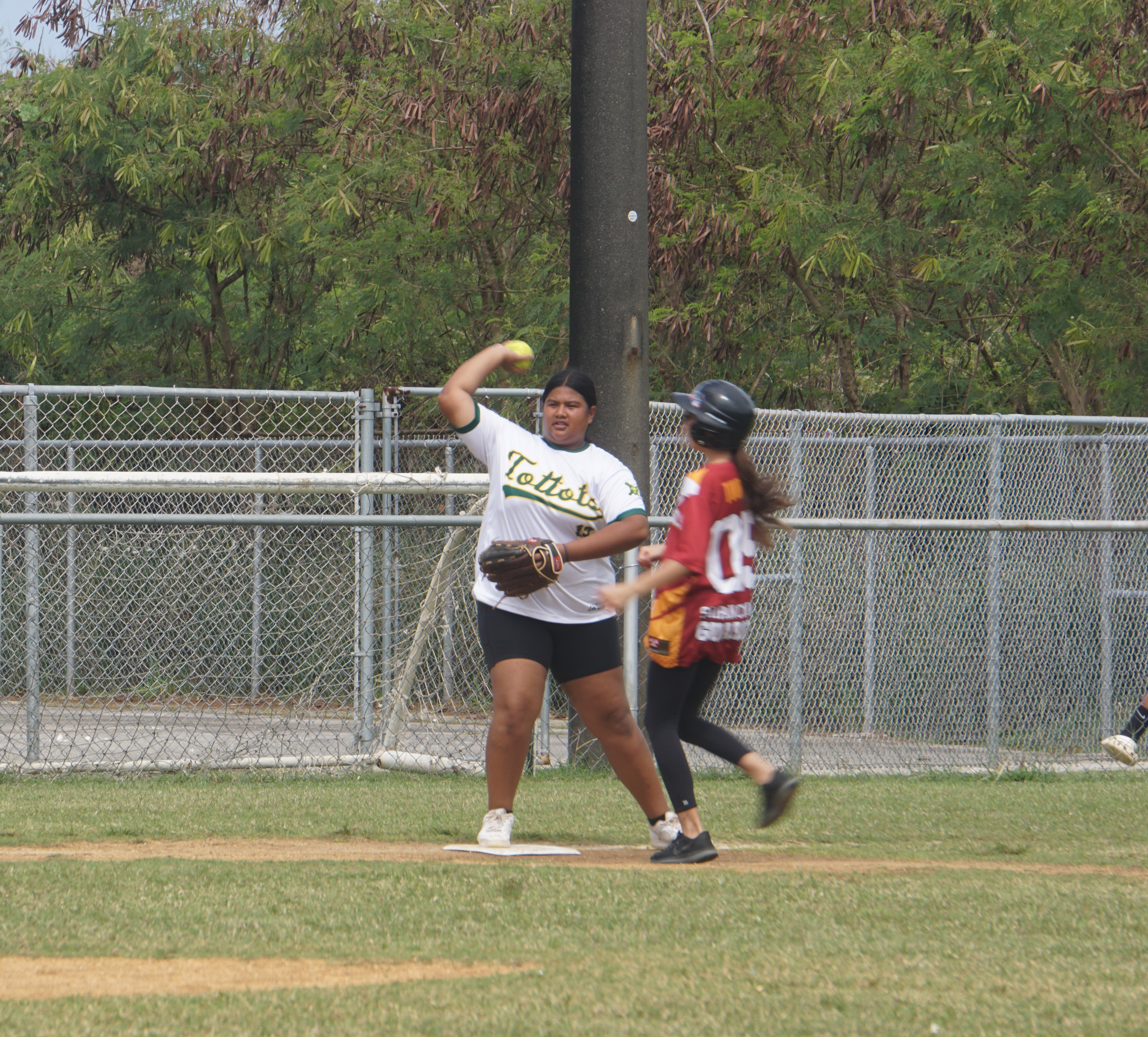 Dandan Middle School's third baseman Elisha Teigita throws to first base after taking out a runner during a girls middle school division game of the SBL-PSS Interscholastic Softball League SY23-24 at the Dandan baseball field.