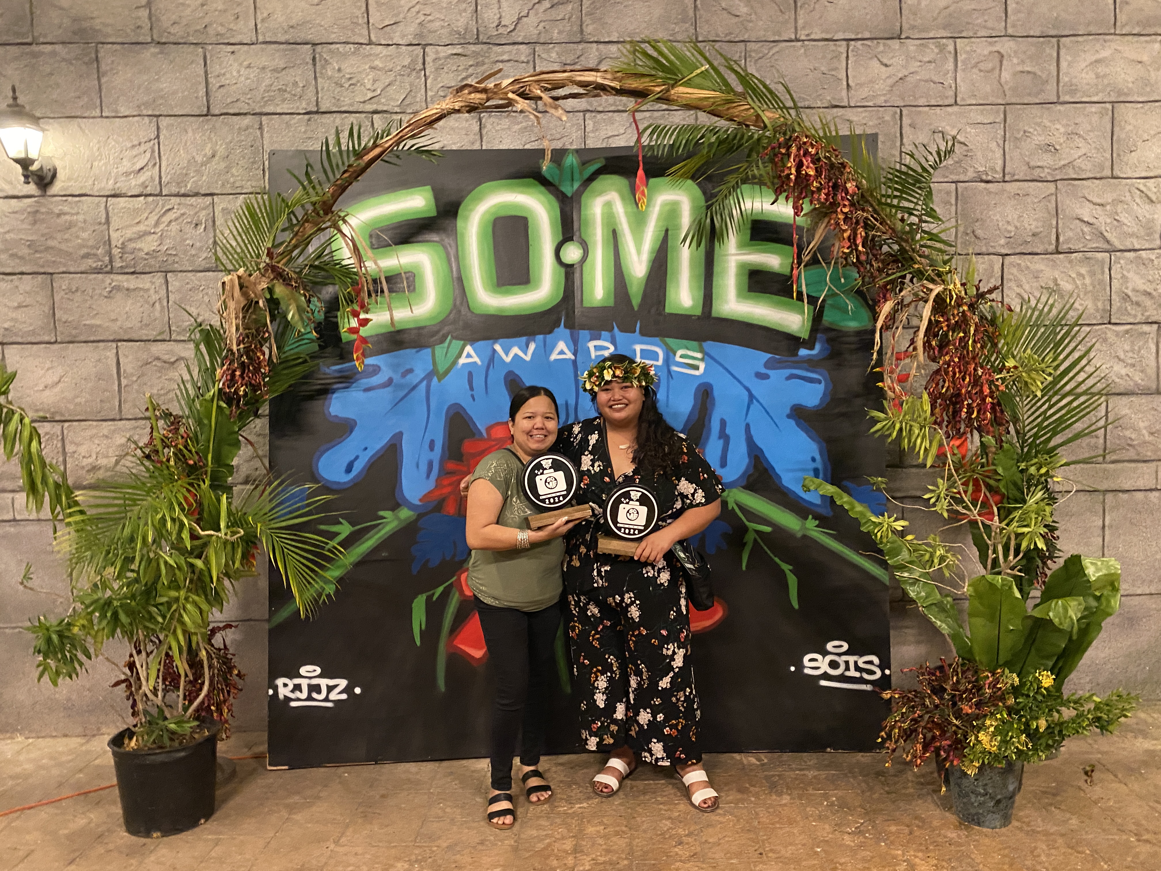 Netty Cee, known for her comedy and food recipes, poses in front of a mural by street artist SOIS. She stands next to Juanicia Villanueva.