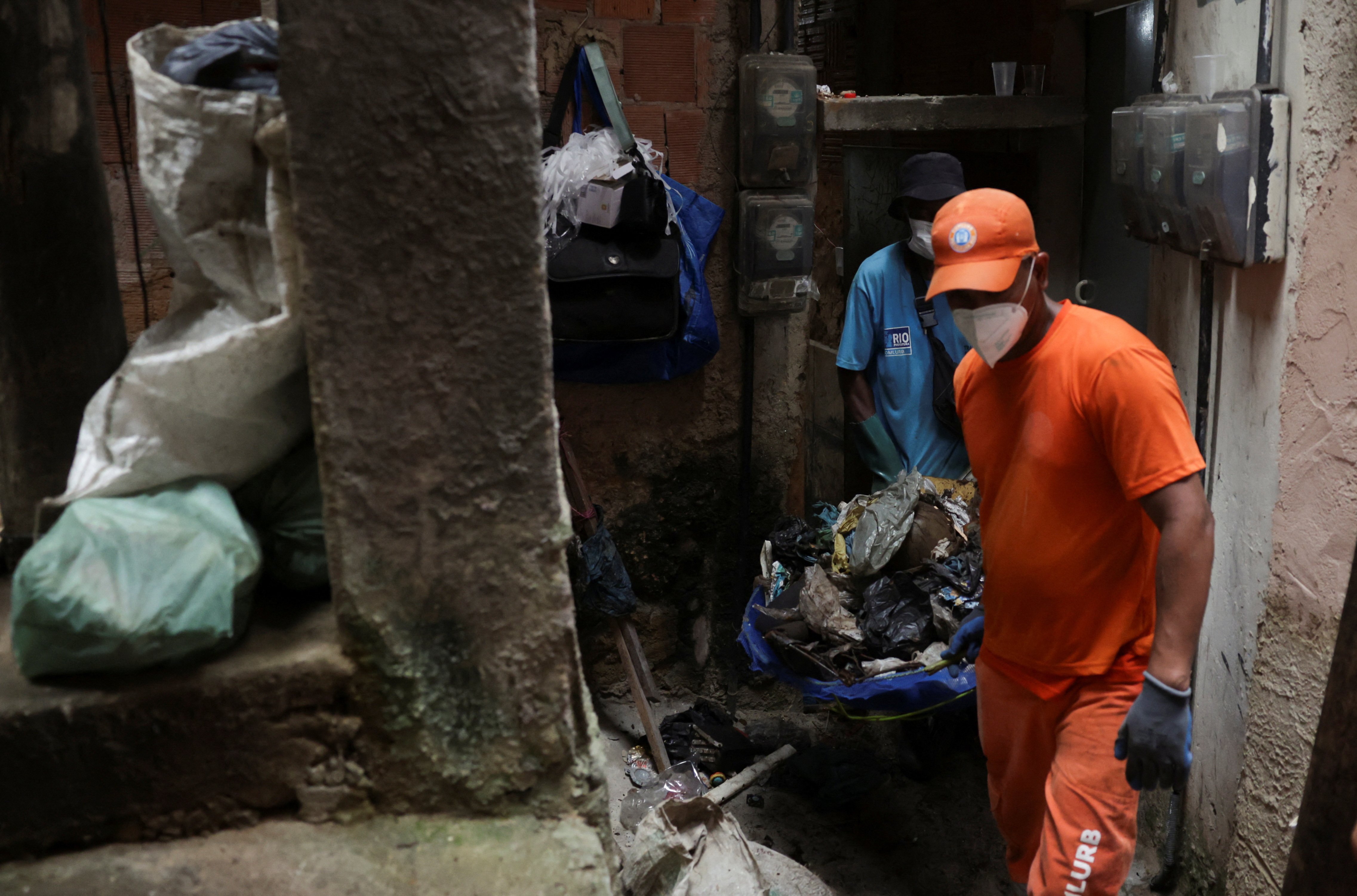 Cleaners and health workers collect garbage from a house, after complaints from residents of potential breeding sites of Aedes aegypti mosquitoes, in Rocinha slum of Rio de Janeiro, Brazil, February 7, 2024. 