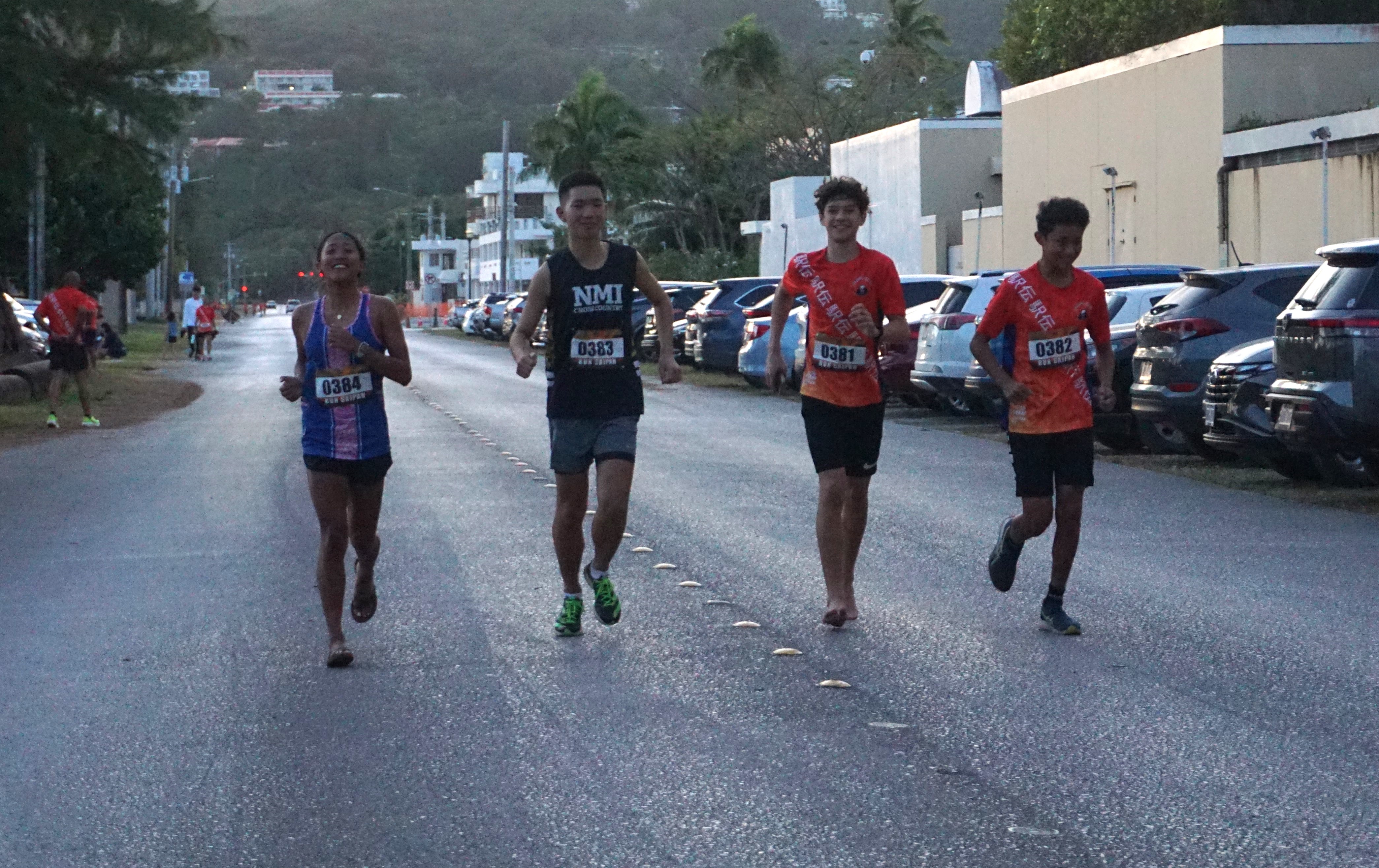Members of Team API reach the finish line of Run Saipan’s 4th Marianas Ekiden at Micro Beach on Saturday. 