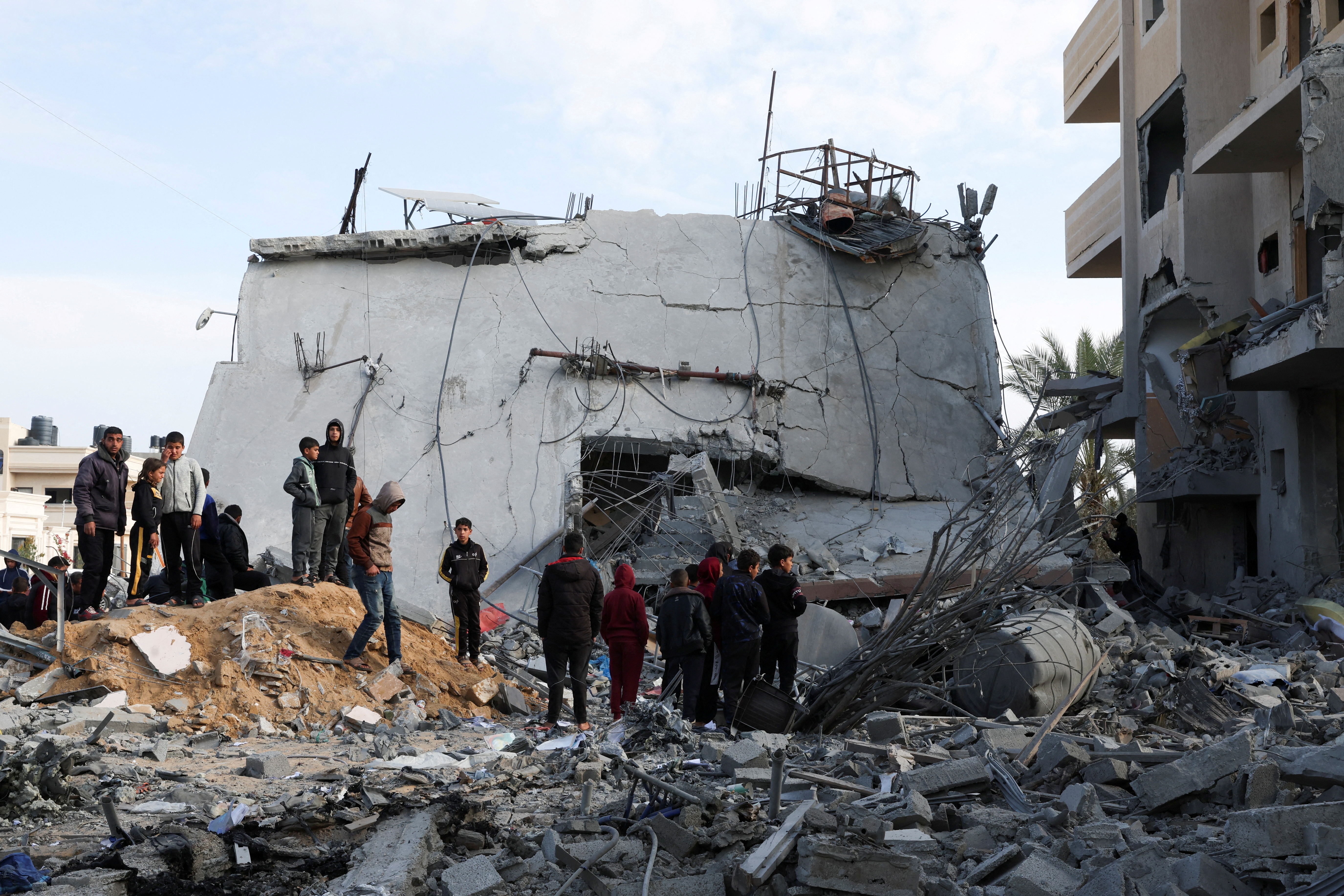 Palestinians gather near a house hit by an Israeli strike, in Rafah in the southern Gaza Strip February 16, 2024. 
