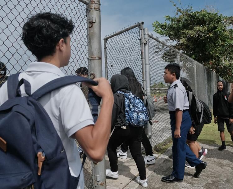 Simon Sanchez High School students enter the John F. Kennedy High School campus to begin their half of double session in Tamuning on Wednesday, Jan. 17, 2024. 