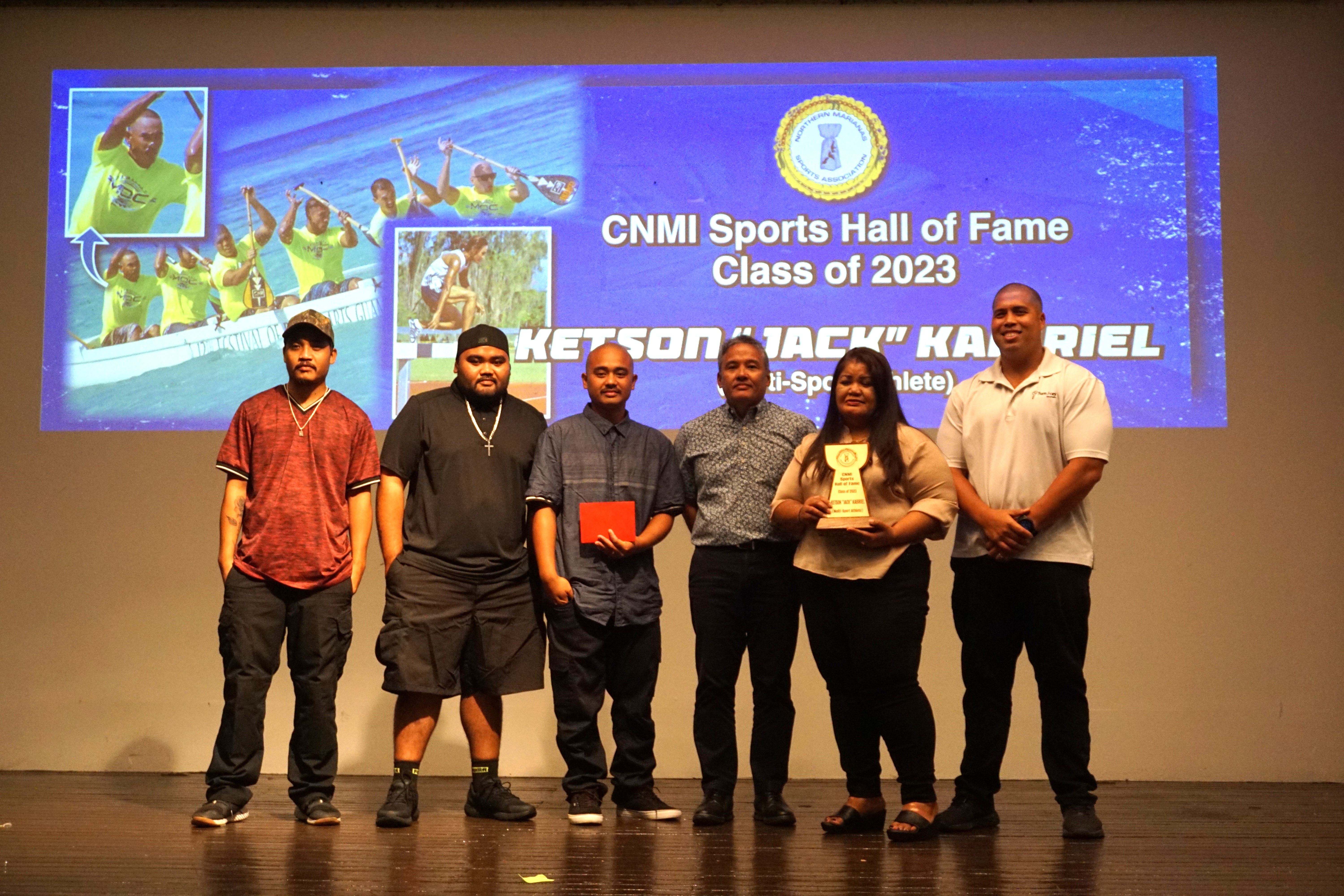 The family members of the late Ketson "Jack" Kabiriel pose for a photo with  Marianas Outrigger Club representative Billy Grow and Northern Marianas Sports Association board member Alex Sablan during the NMSA Annual Awards Banquet at the Hibiscus Hall of the Crowne Plaza Resort Saipan on Wednesday evening.