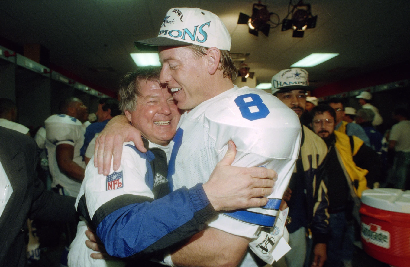 Dallas Cowboys’ head coach Jimmy Johnson hugs quarterback Troy Aikman in their locker room after defeating the Buffalo Bills 30-13 in Super Bowl XXVIII at the Georgia Dome in Atlanta, Jan. 30, 1994.