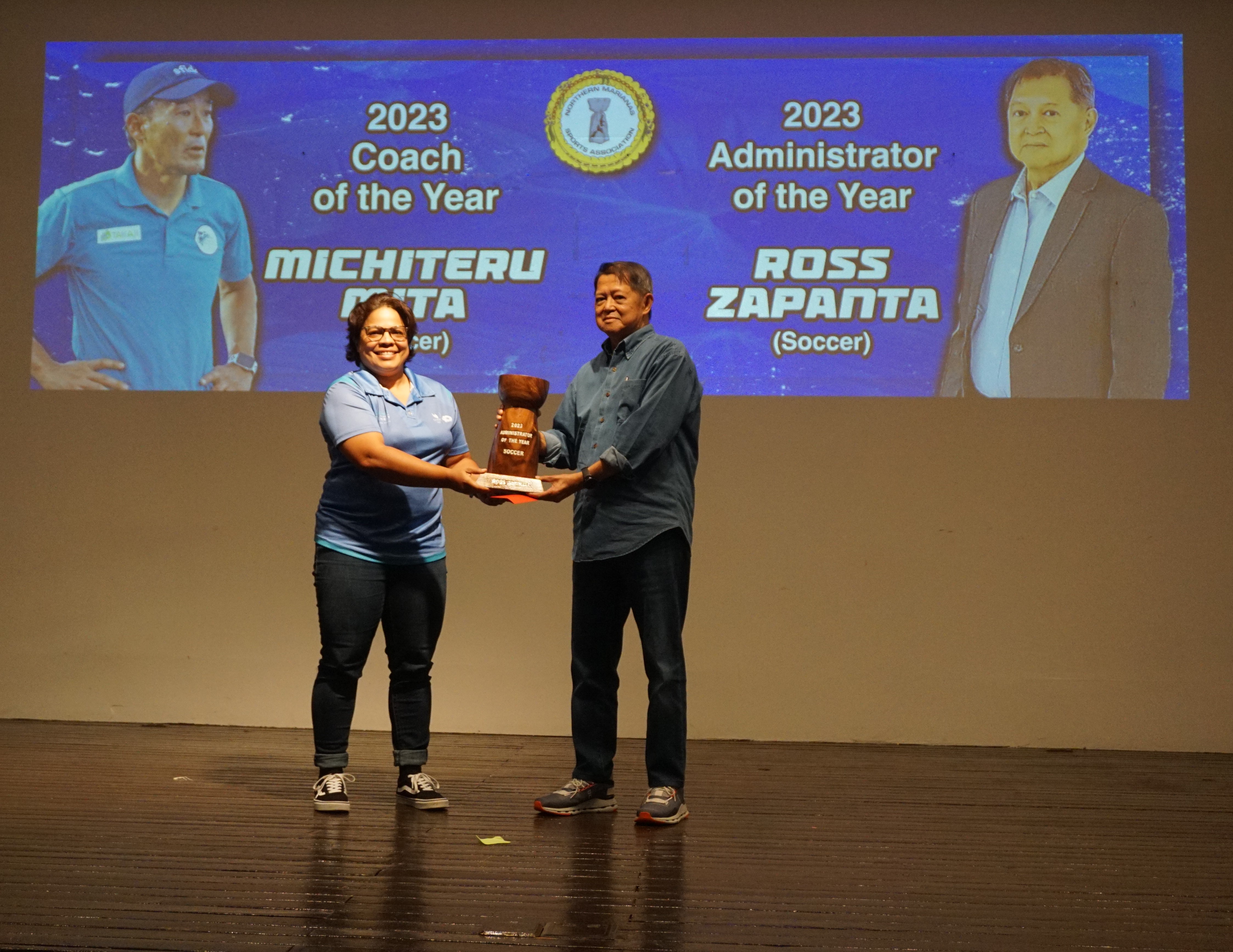 Ross Zapanta, right, receives the Administrator of the Year trophy from Northern Marianas Sports Association General Secretary Valerie Hofschneider during the 2023 NMSA Annual Awards Banquet at the Hibiscus Hall of Crowne Plaza Resort Saipan.