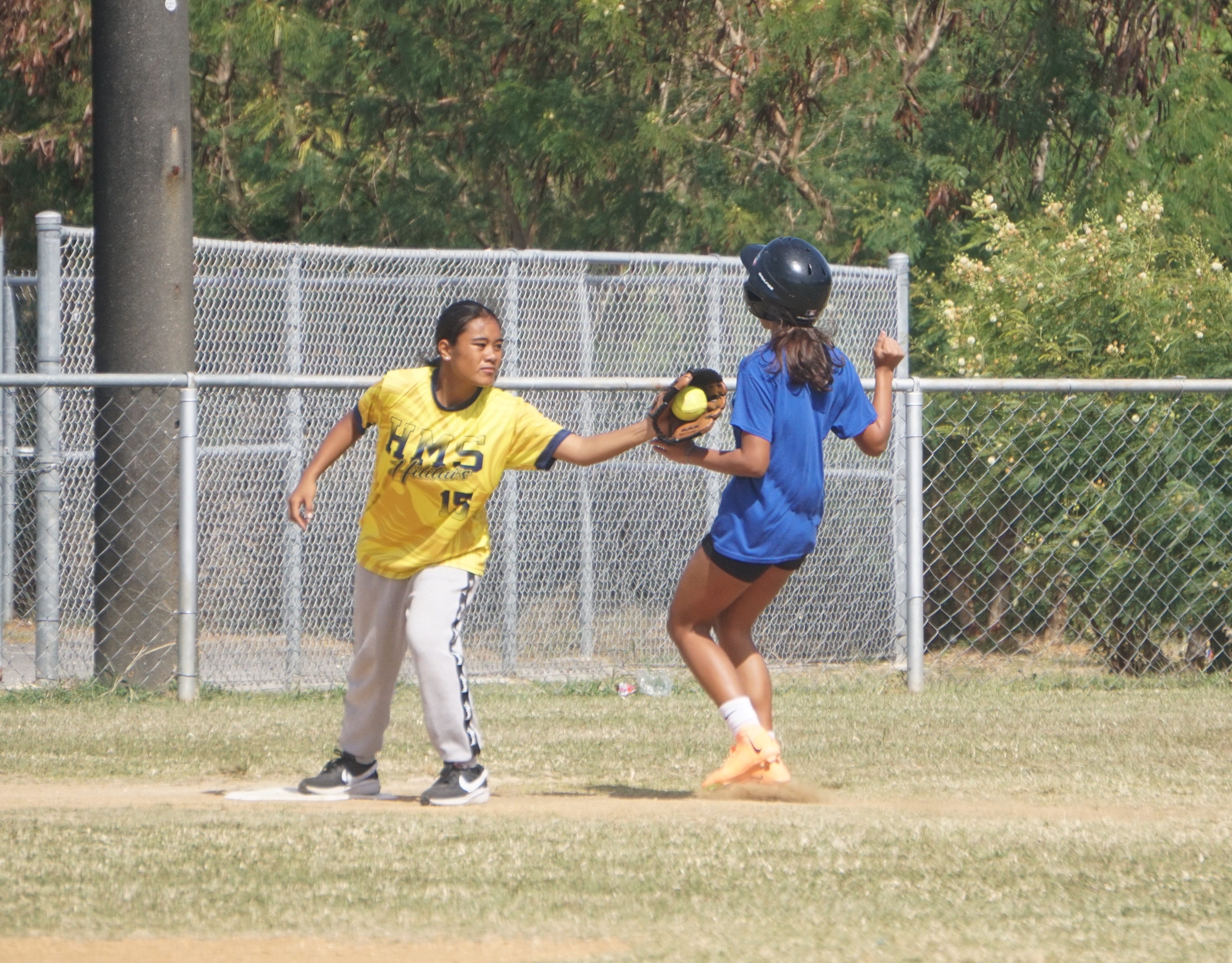 Hopwood third baseman Mika Daikichy catches the ball for the out before an MCS runner reaches the base during a girls middle school division game of the SBL-PSS Interscholastic Softball League SY23-24 at the Dandan baseball field on Saturday.