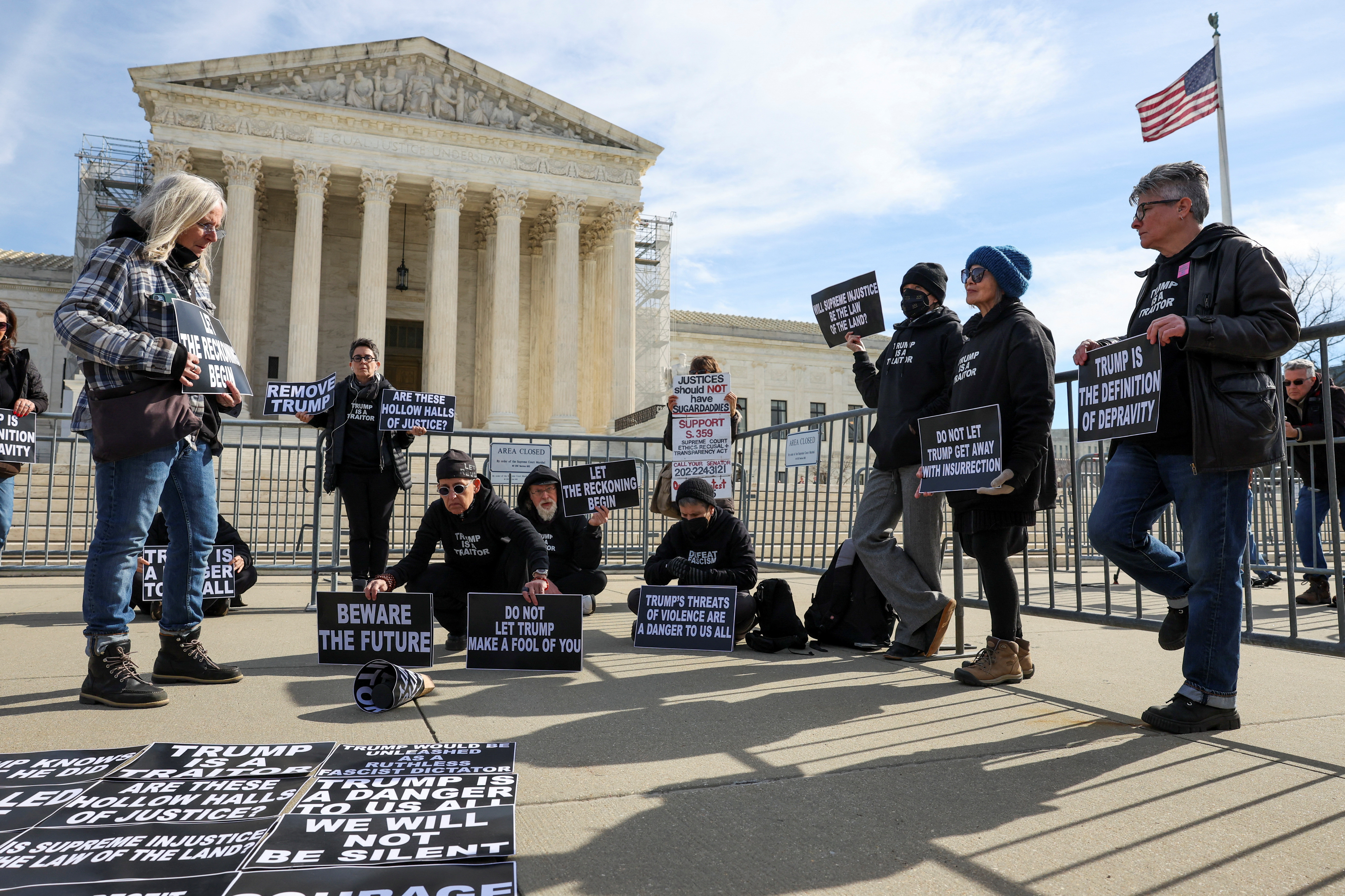 Activists listen to proceedings outside the U.S. Supreme Court as justices hear arguments in former U.S. President Donald Trump's appeal of a lower court's ruling disqualifying him from the Colorado presidential primary ballot, in Washington, U.S., February 8, 2024. 